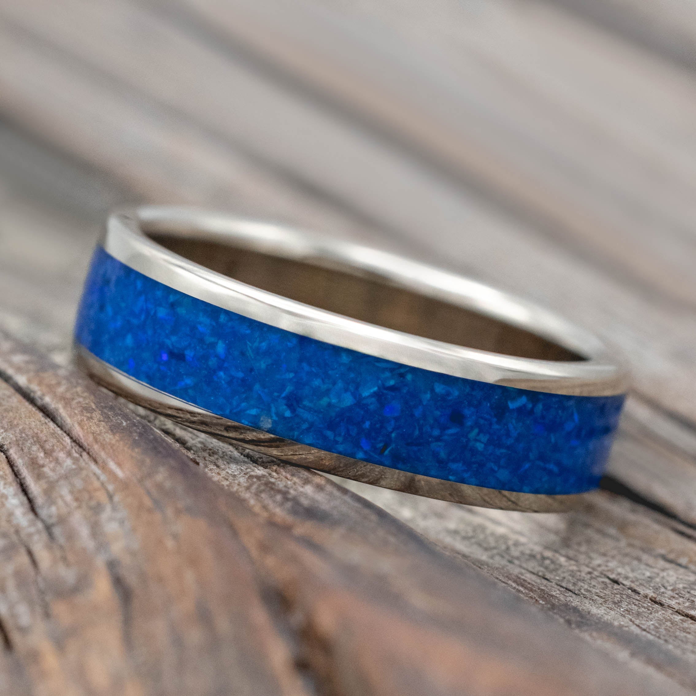 14K white gold ring with blue opal inlay on a wooden surface