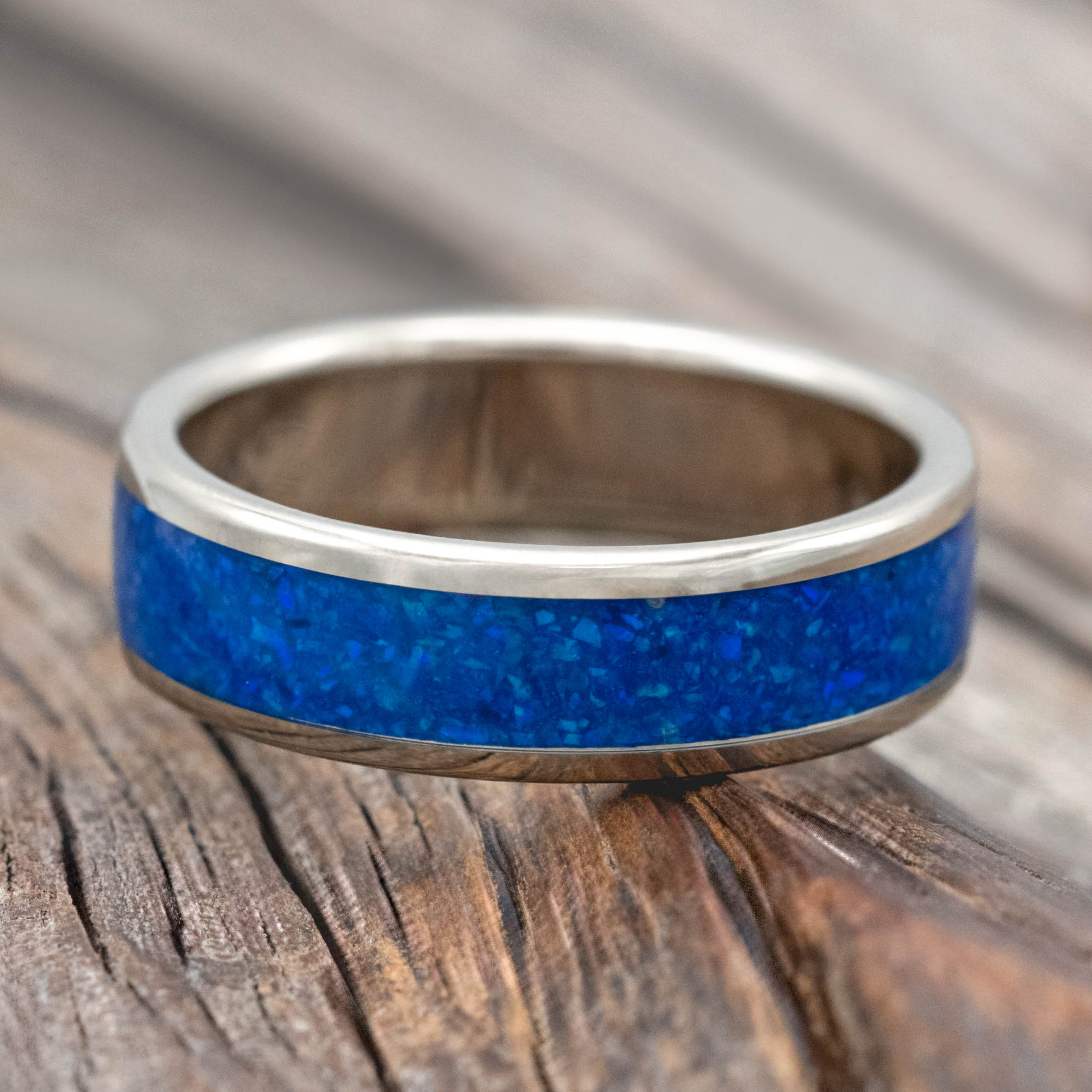 14K white gold ring with blue opal inlay on a wooden surface