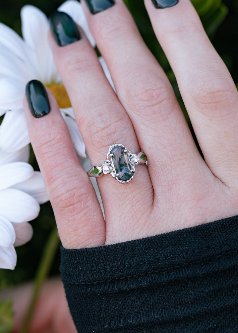 On hand of "Rosetta" - floral-inspired hexagon moss agate women's engagement ring with diamond accents & moss inlays