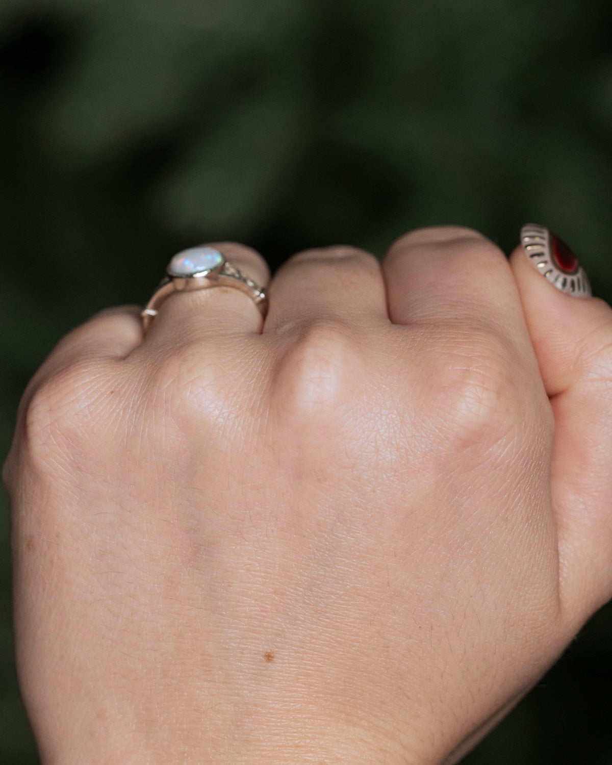 On hand photo of "Selene" - Australian opal women's engagement ring with crescent moon engravings in 14K white gold