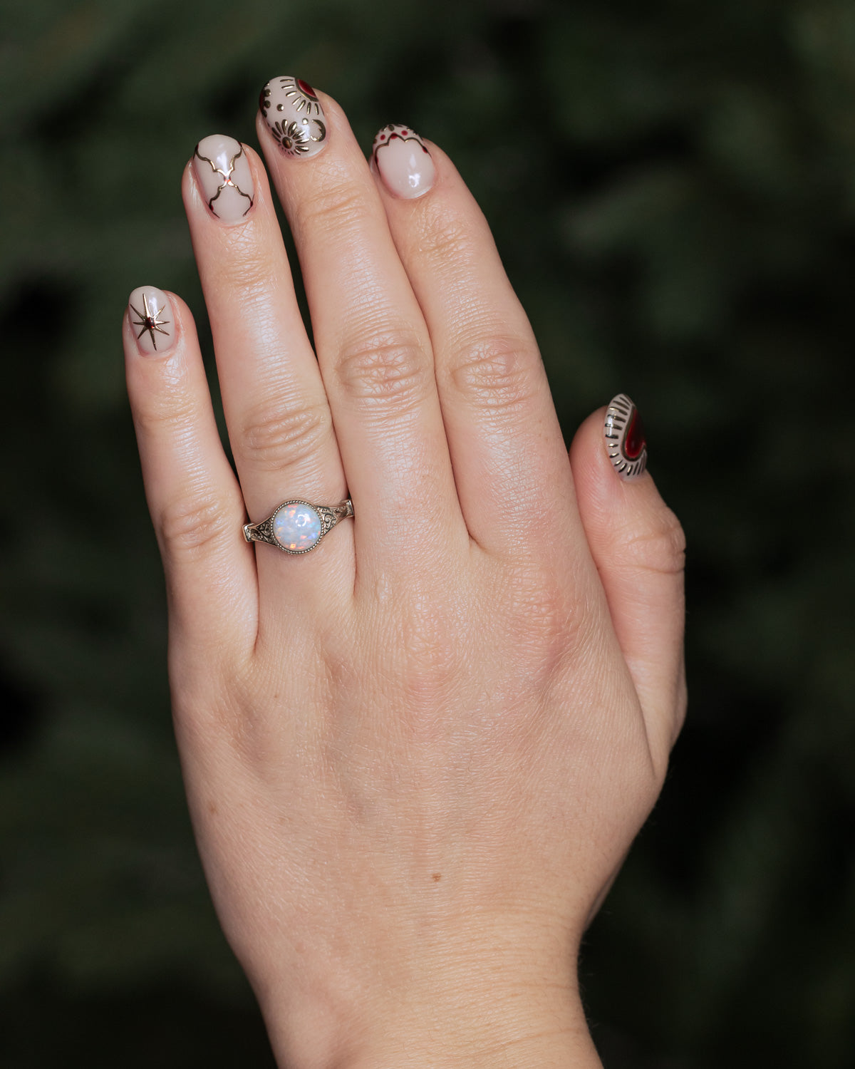 On hand photo of "Selene"  - Australian opal women's engagement ring with crescent moon engravings in 14K white gold