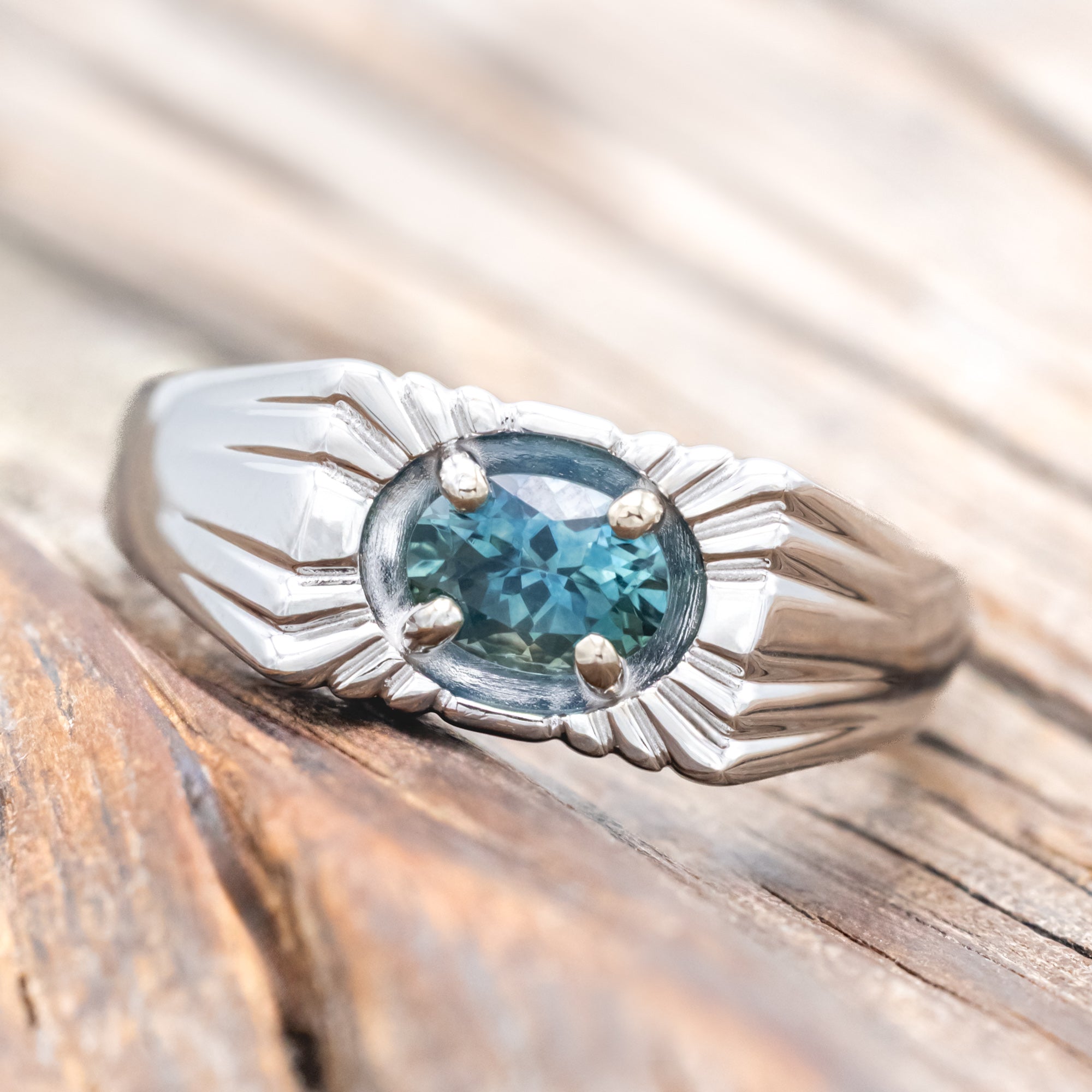 14K gold ring with a Montana sapphire on a wooden surface