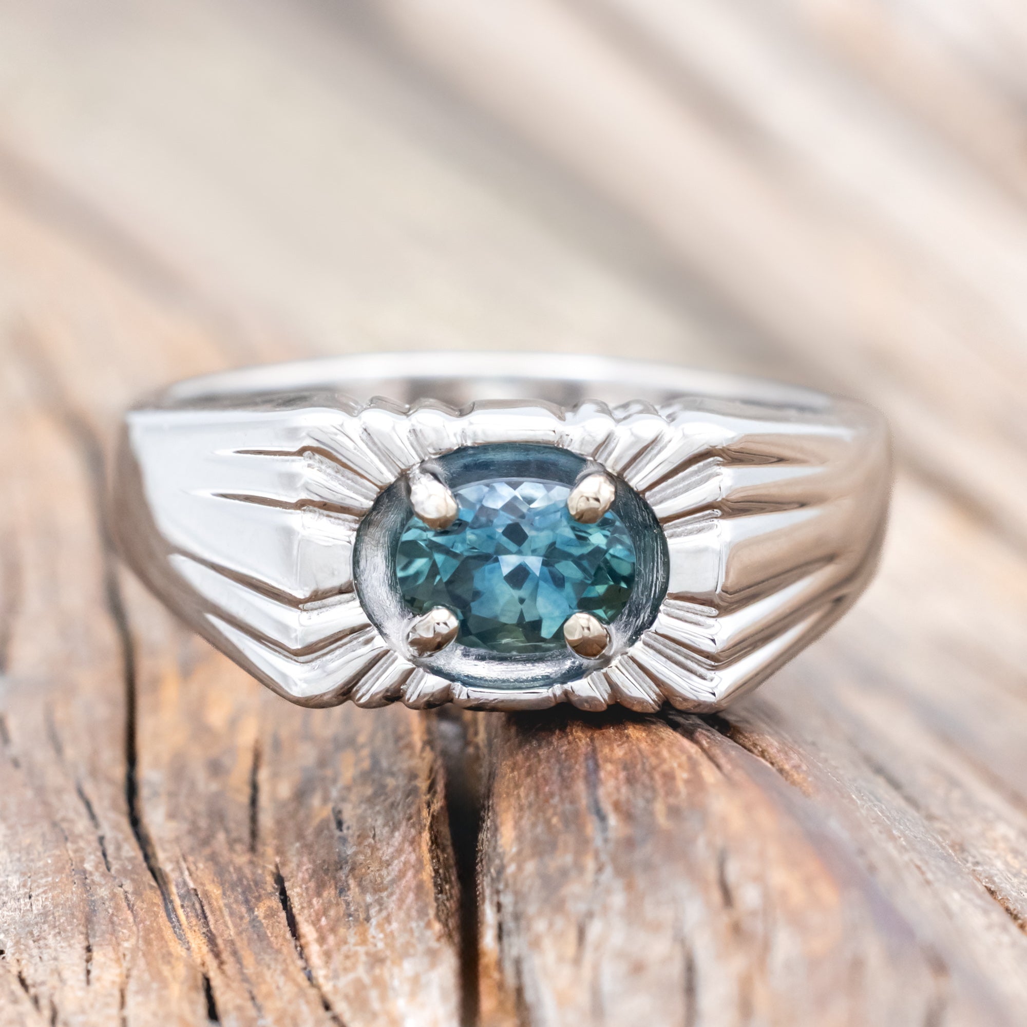 14K gold ring with a Montana sapphire on a wooden surface