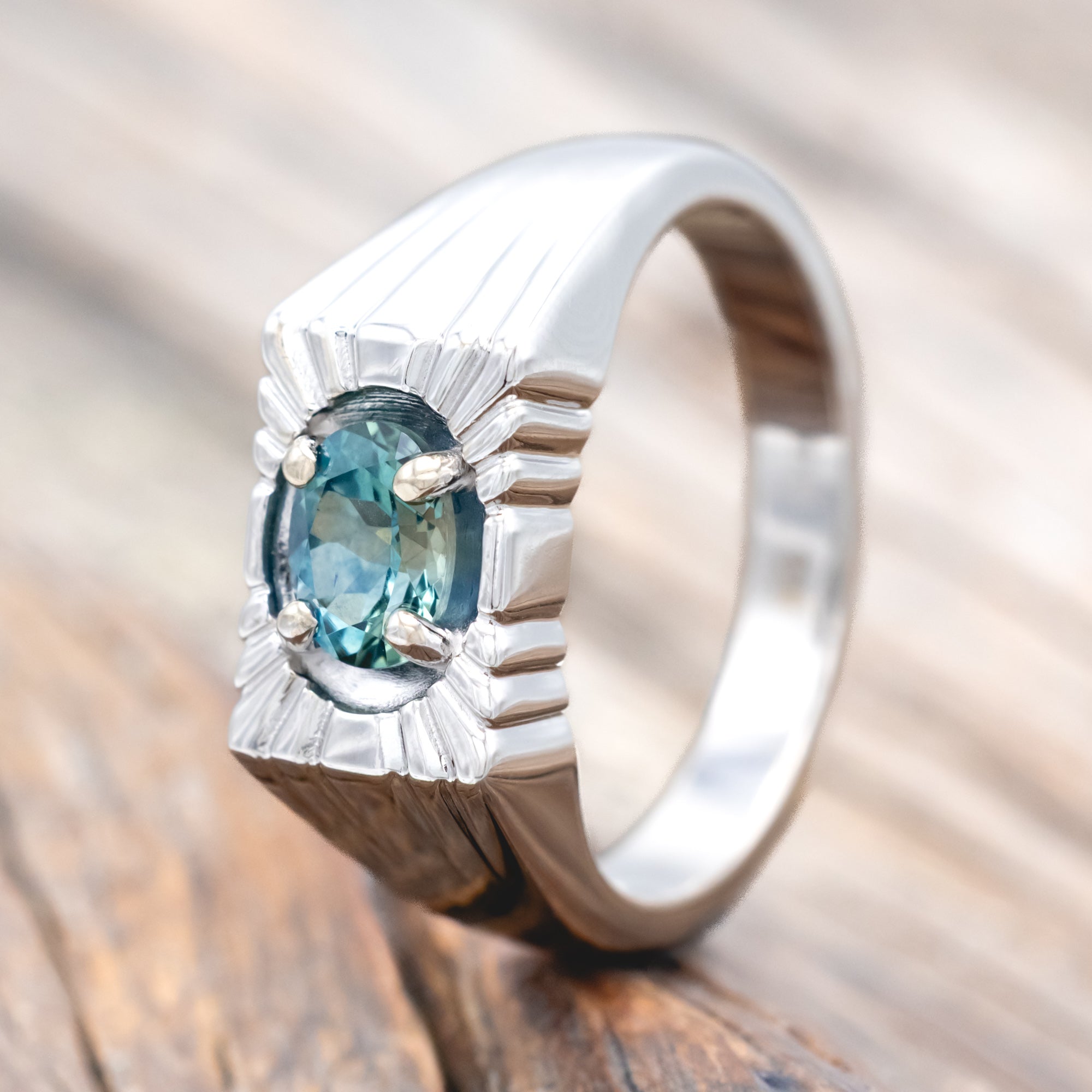 14K gold ring with a Montana sapphire on a wooden surface