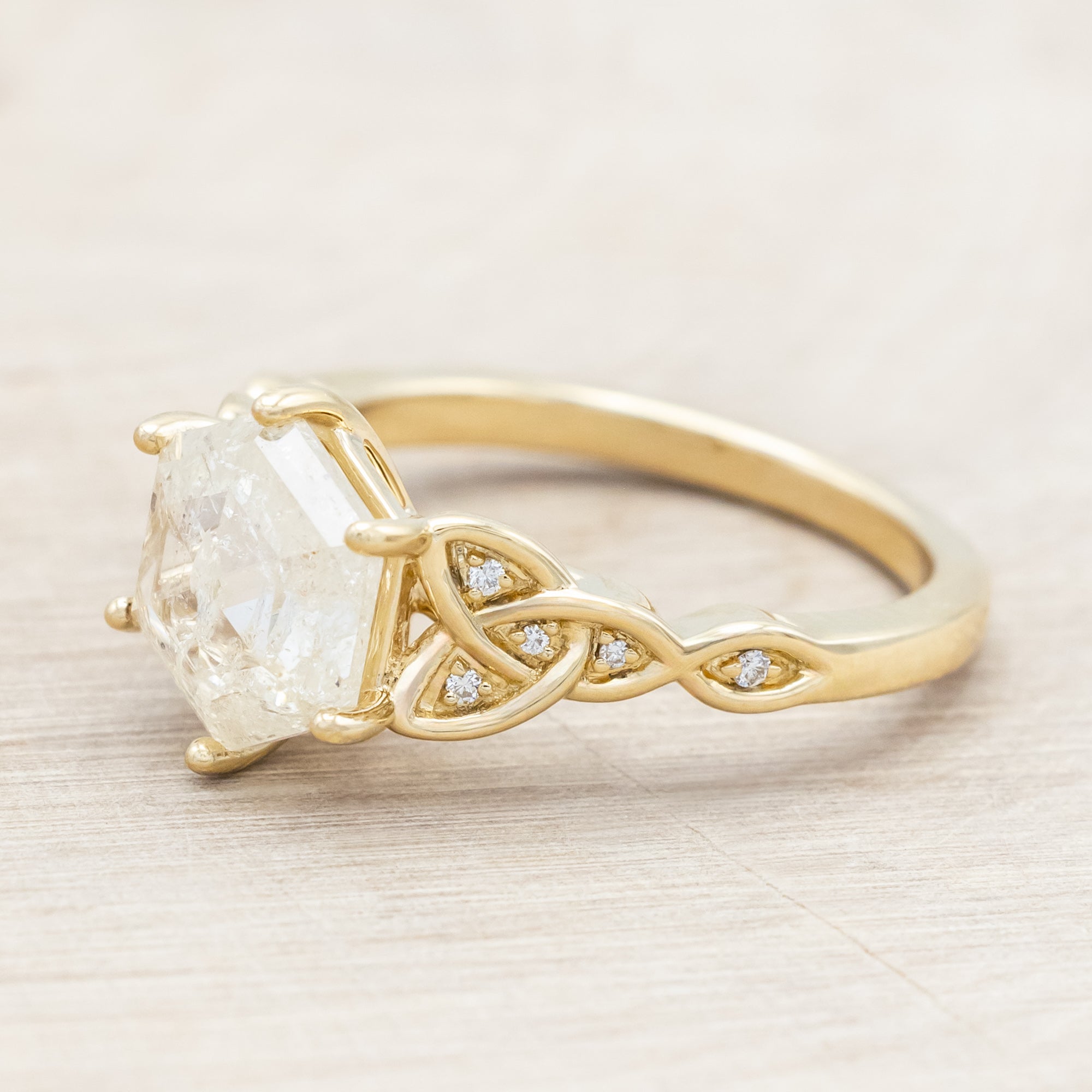 14K gold ring with an icy salt & pepper diamond on a beige background