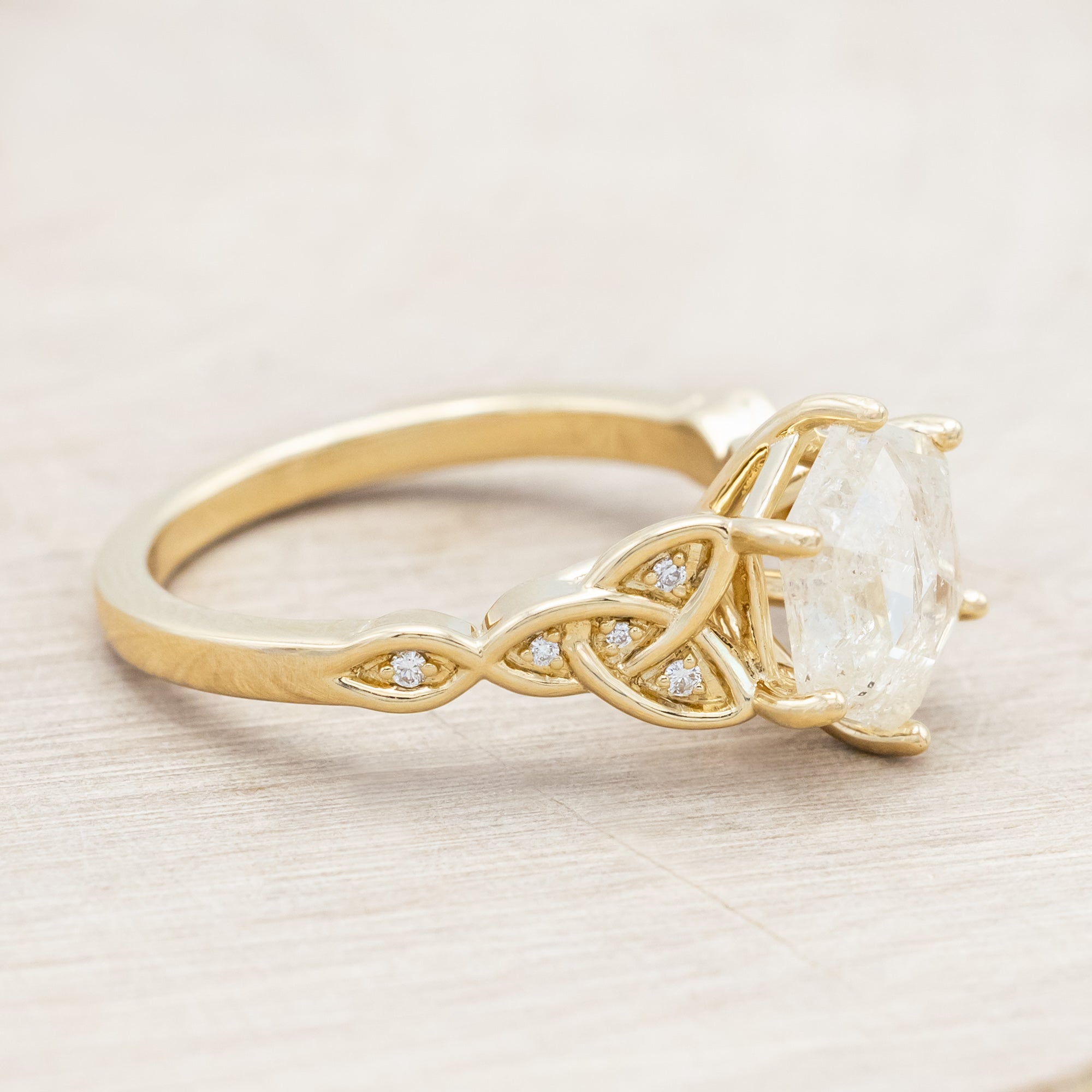 14K gold ring with an icy salt & pepper diamond on a beige background