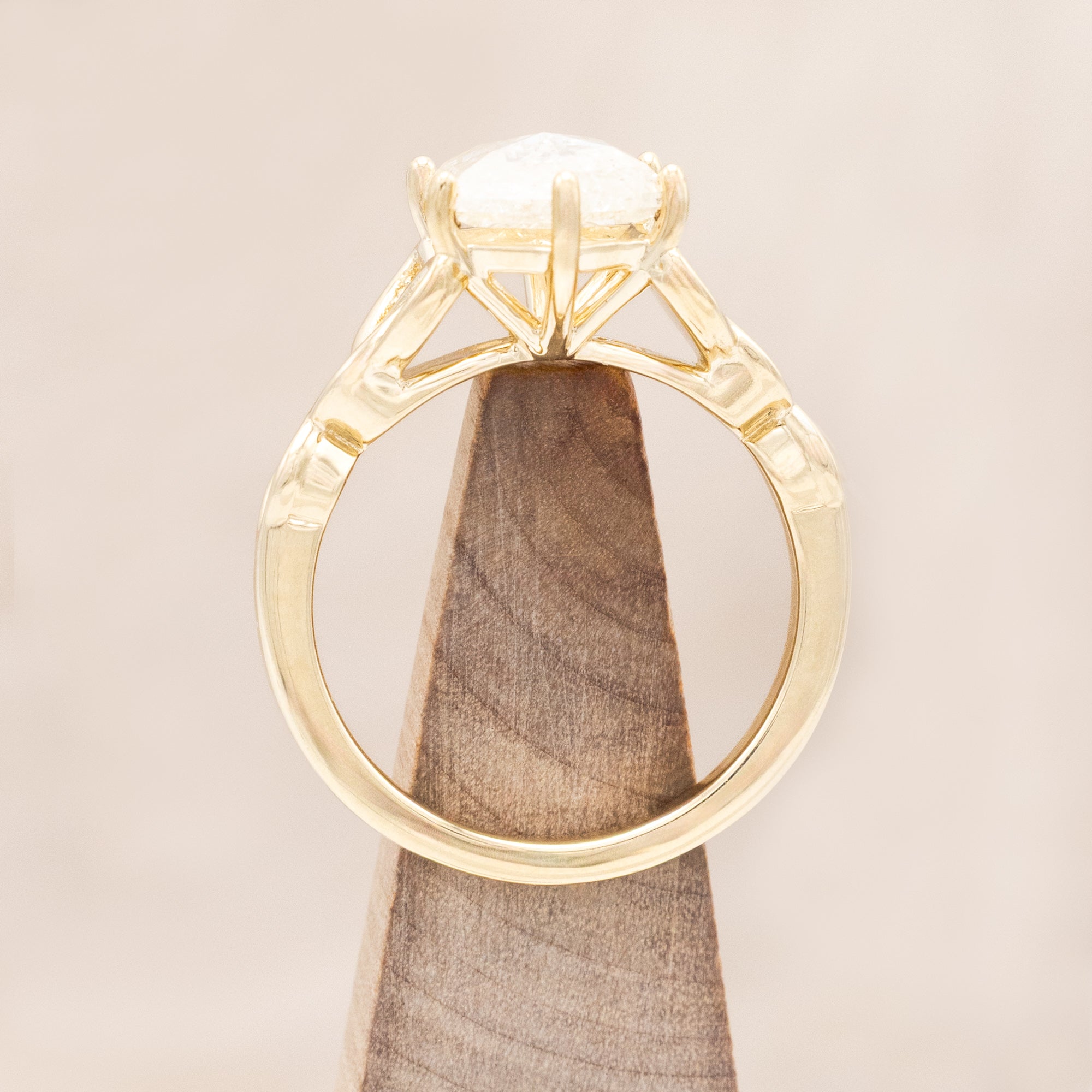 14K gold ring with an icy salt & pepper diamond on a beige background