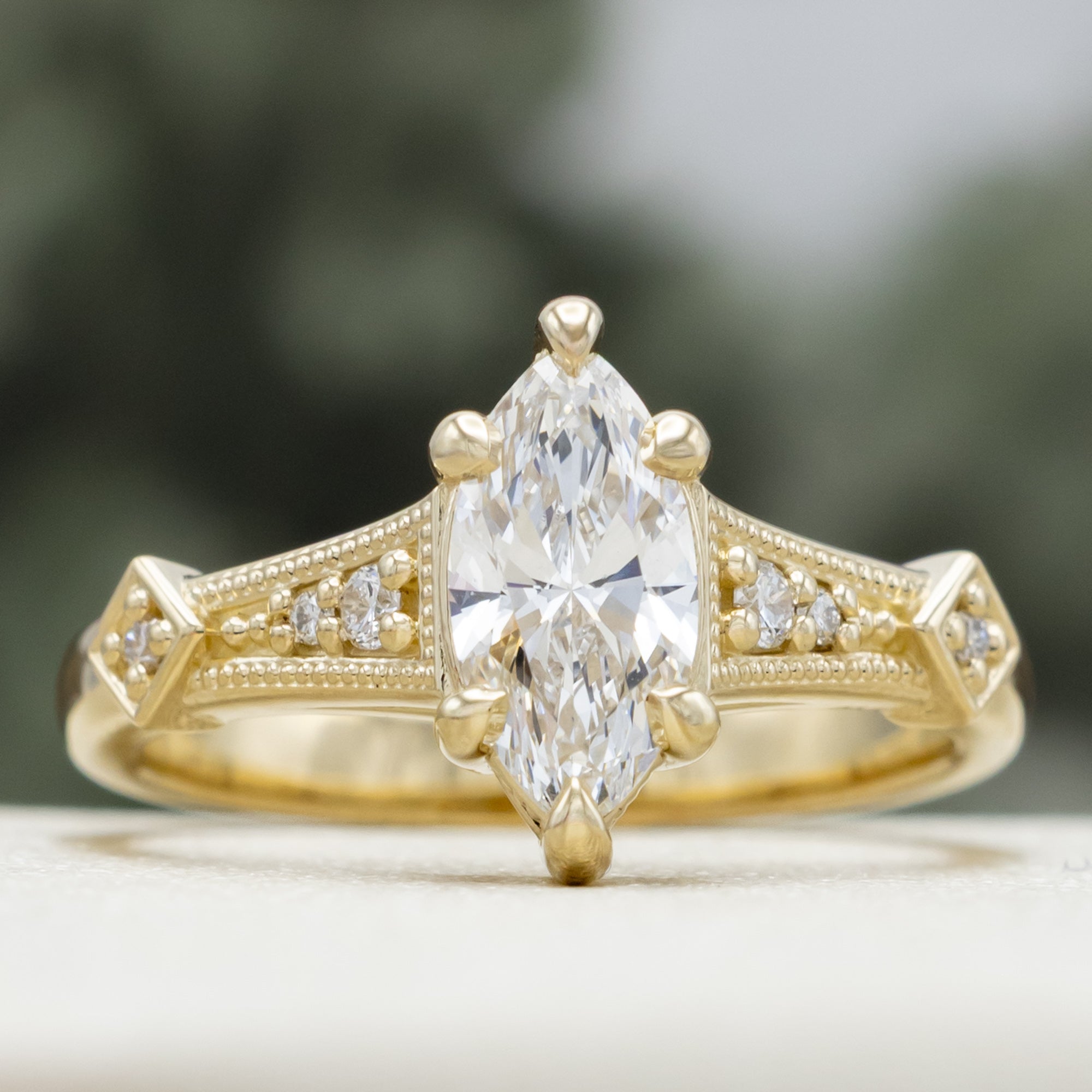 Gold lab diamond ring with diamond accents on a blurred background