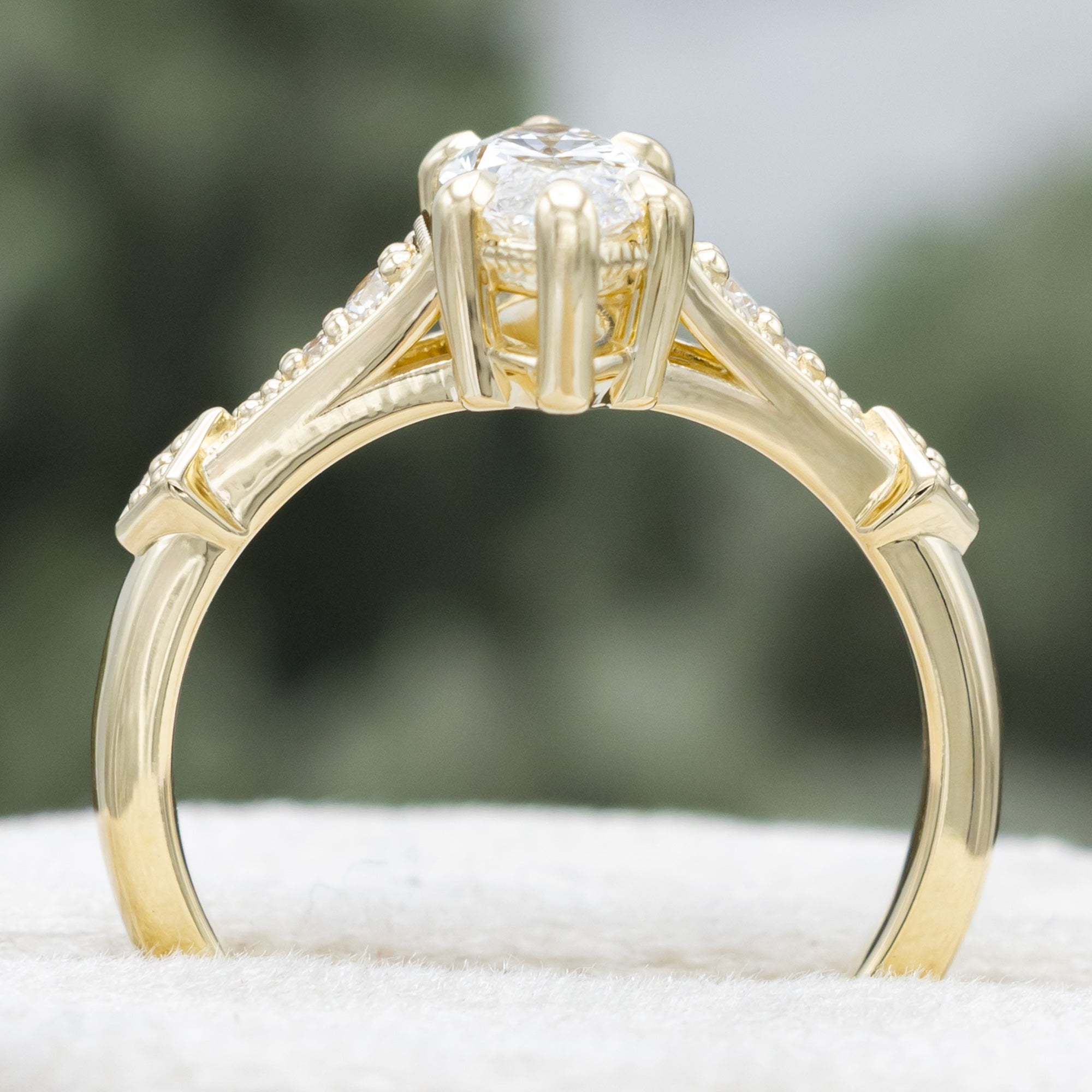Gold lab diamond ring with diamond accents on a blurred background
