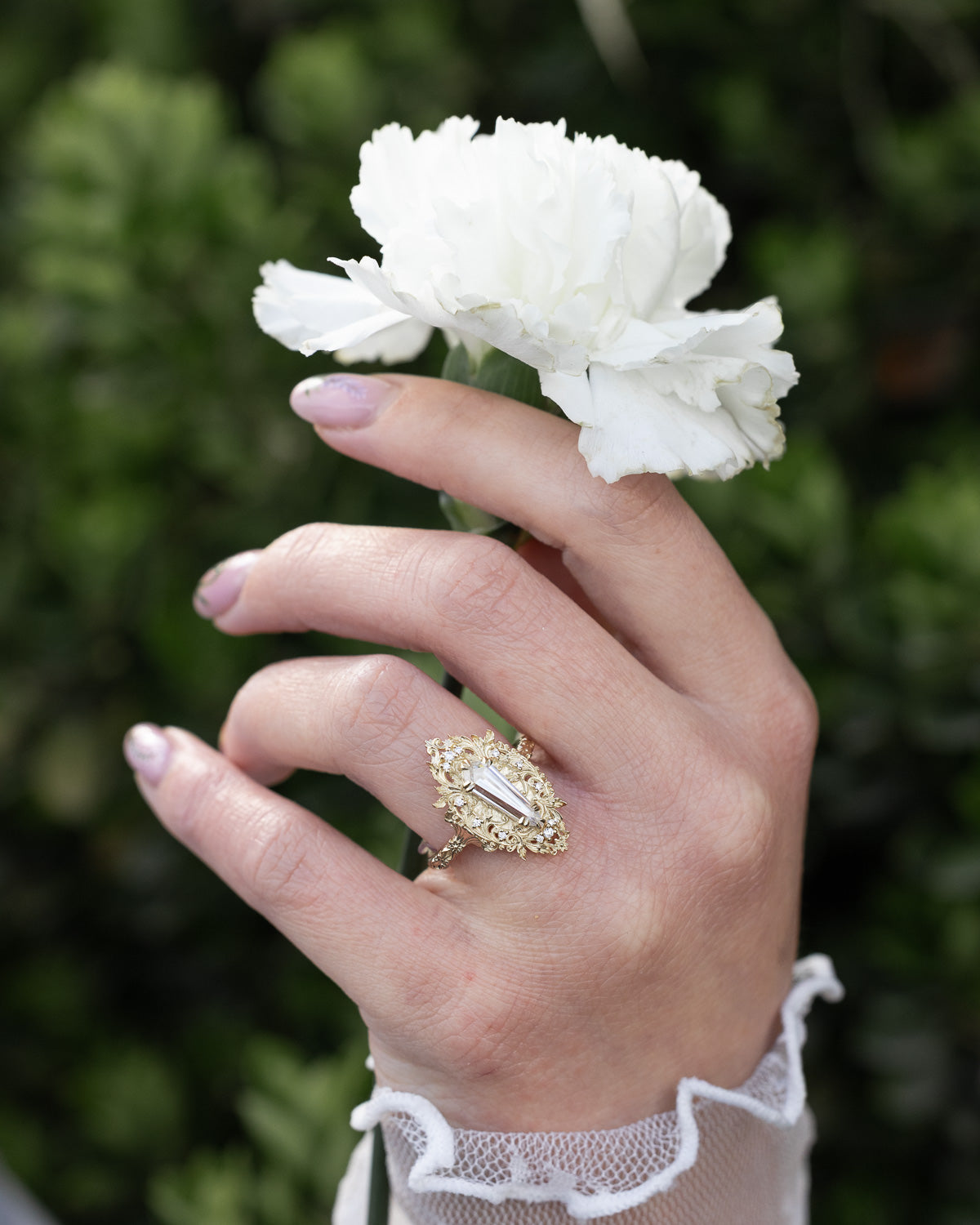 On hand picture of "Cherie" - rococo-inspired Moissanite women's engagement ring with diamond accents