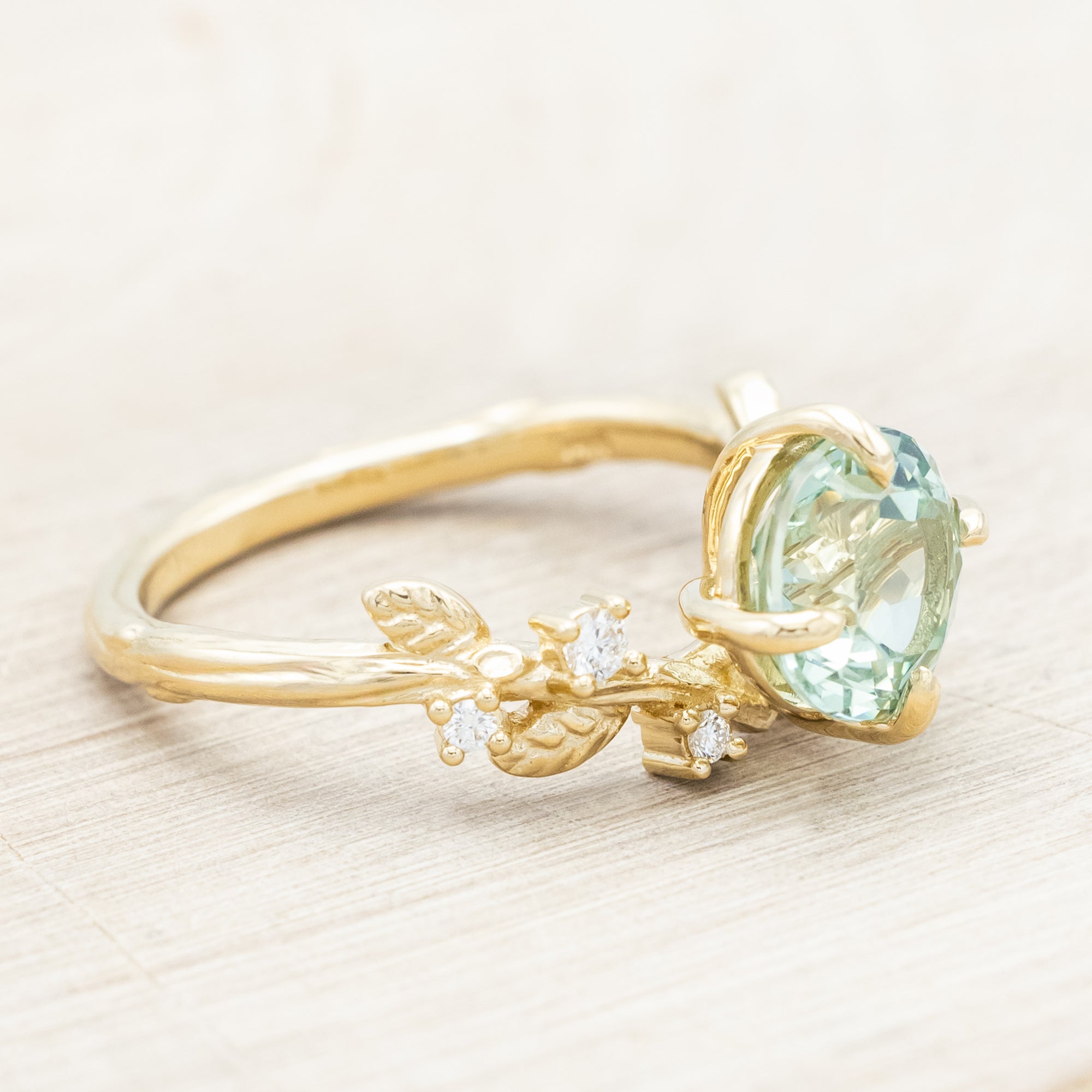 Yellow gold ring with a large sapphire and diamond accents on a neutral background