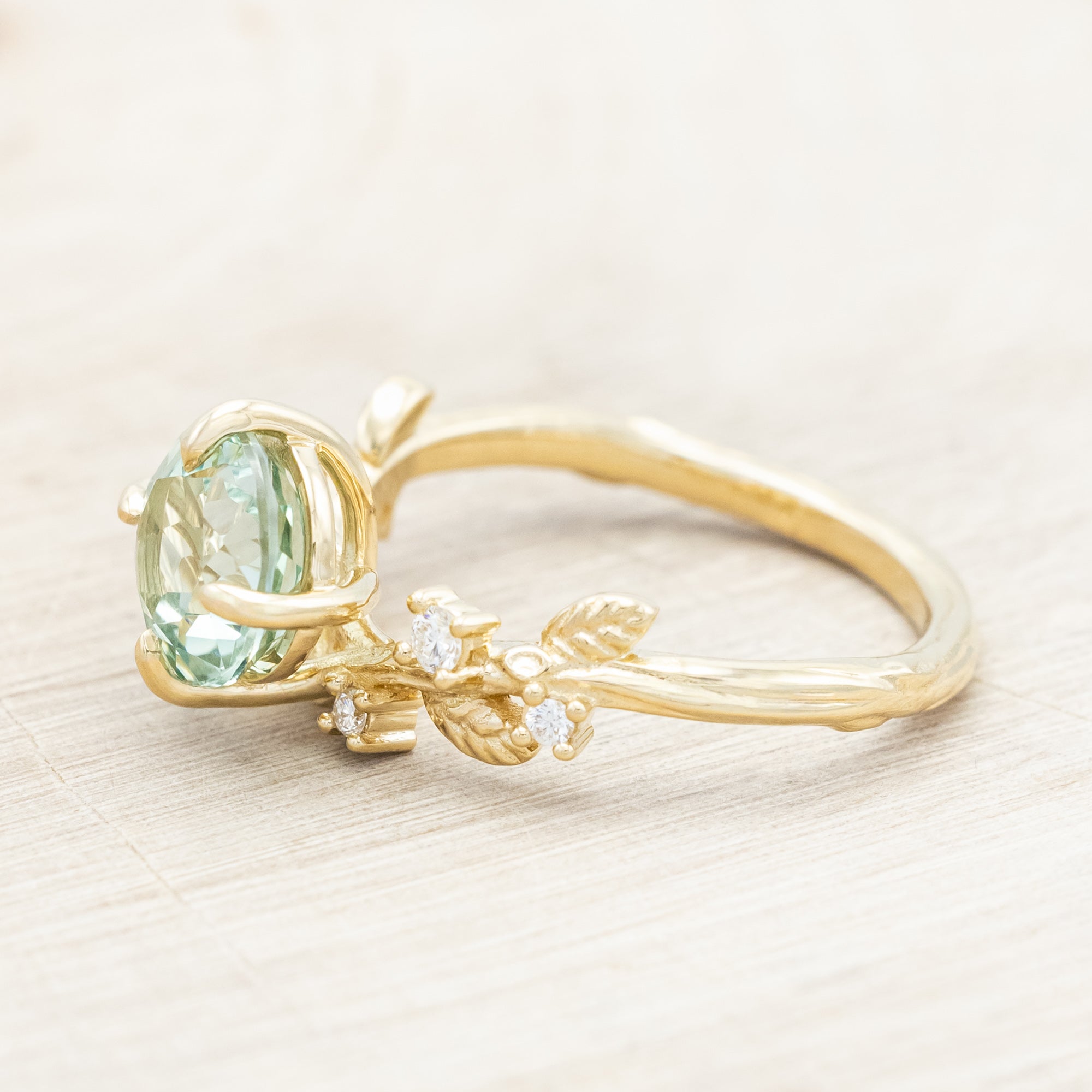 Yellow gold ring with a large sapphire and diamond accents on a neutral background