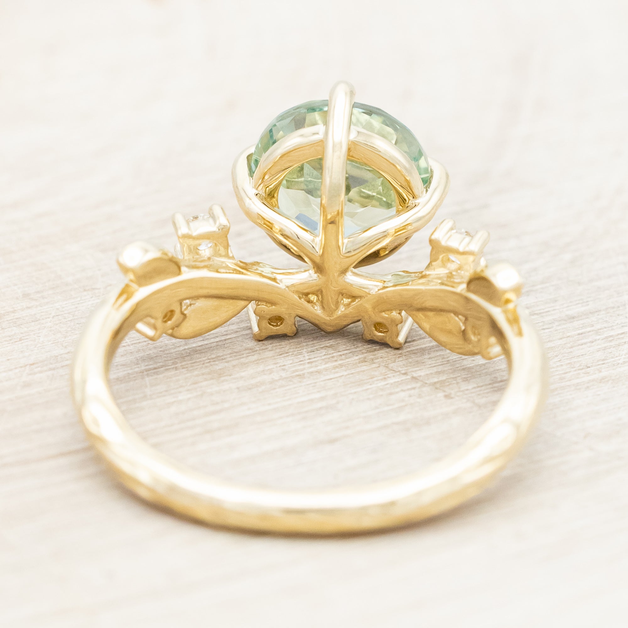 Yellow gold ring with a large sapphire and diamond accents on a neutral background