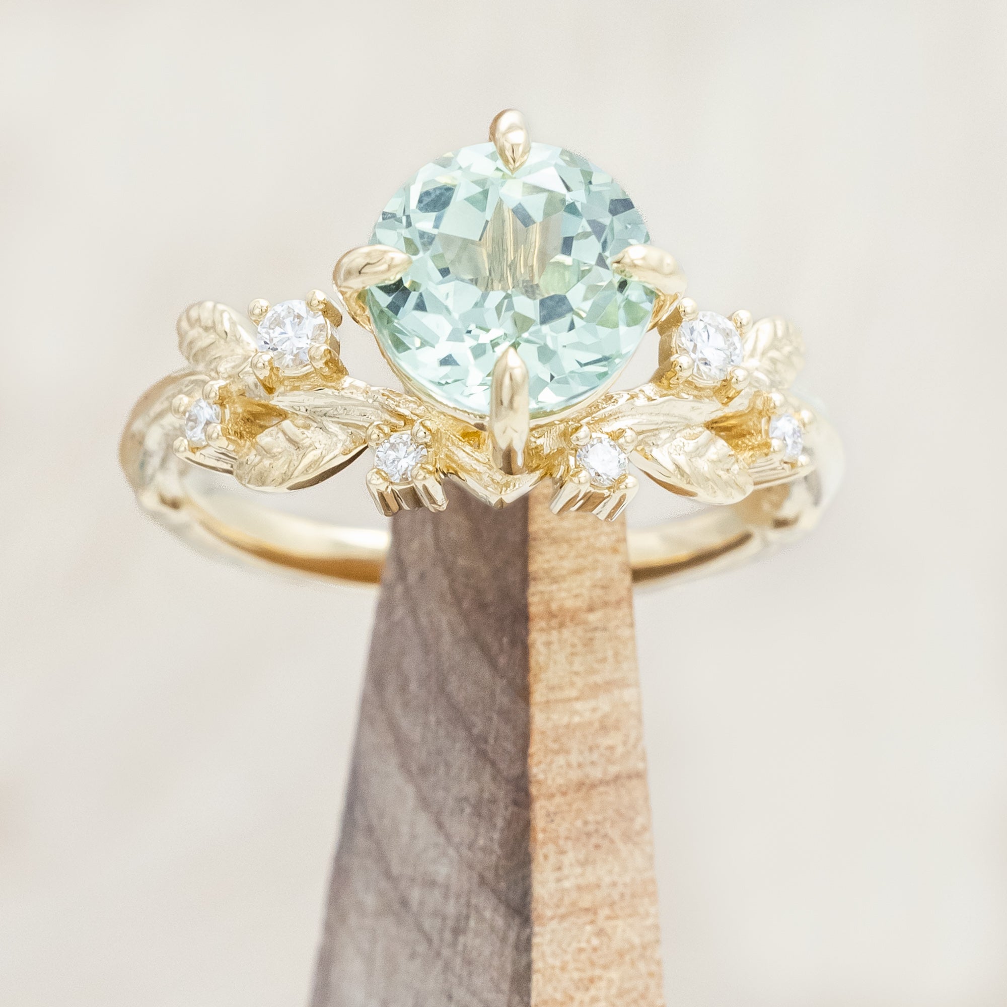 Yellow gold ring with a large sapphire and diamond accents on a neutral background