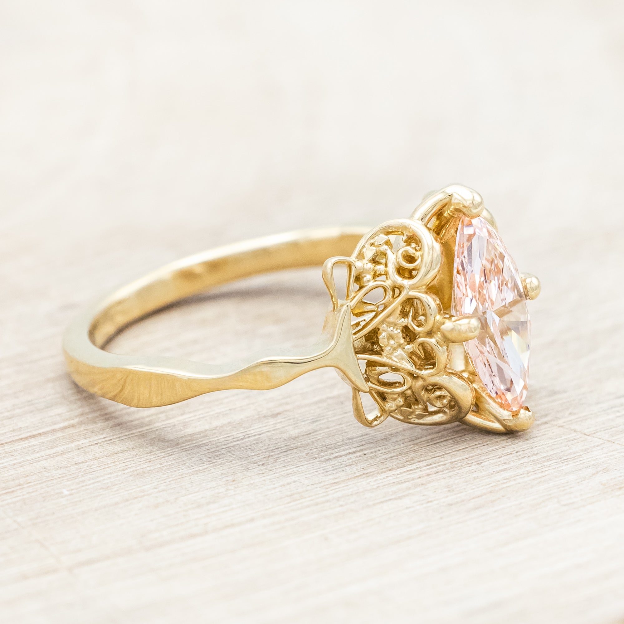 14K yellow gold ring with a pink lab diamond on a neutral background