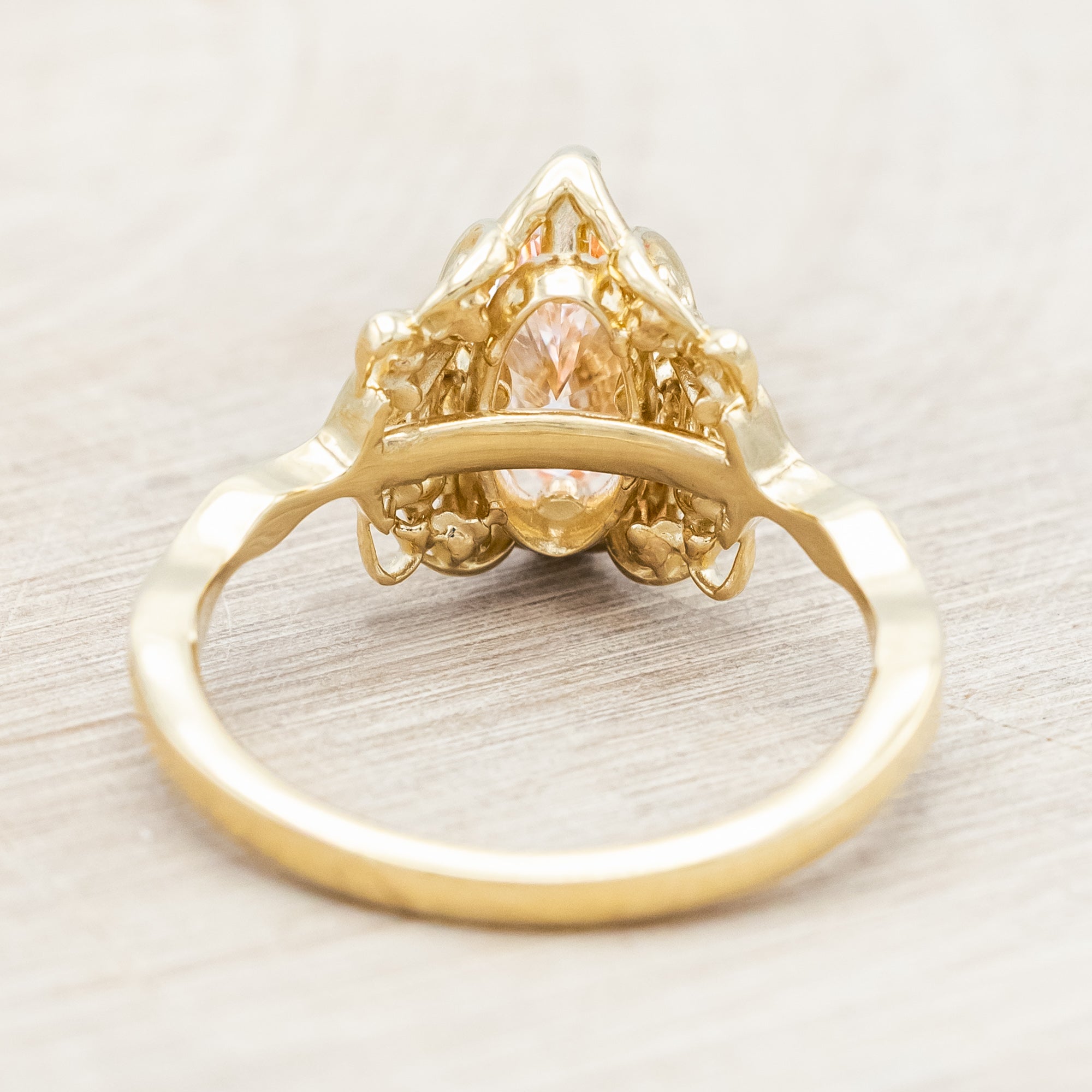 14K yellow gold ring with a pink lab diamond on a neutral background