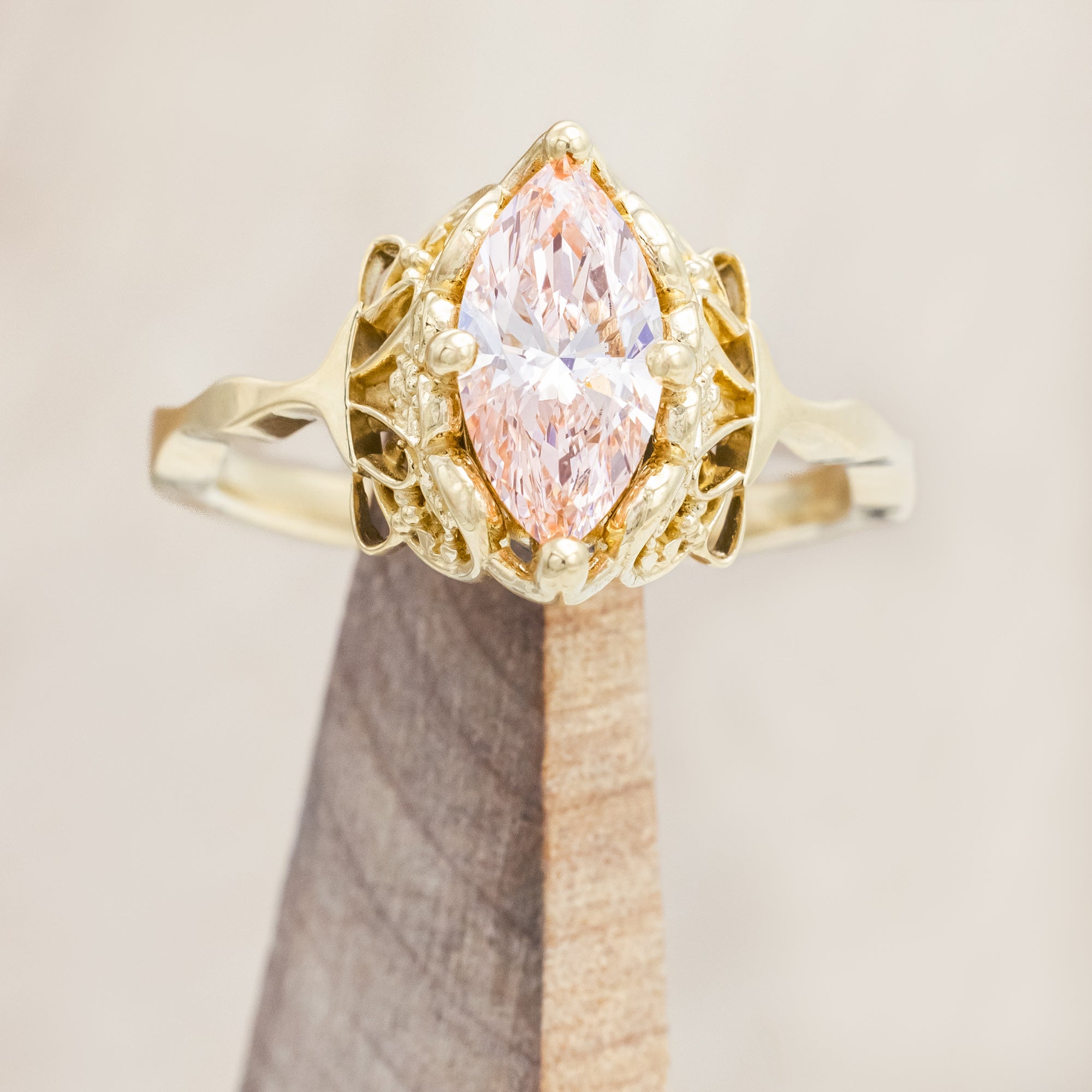 14K yellow gold ring with a pink lab diamond on a neutral background