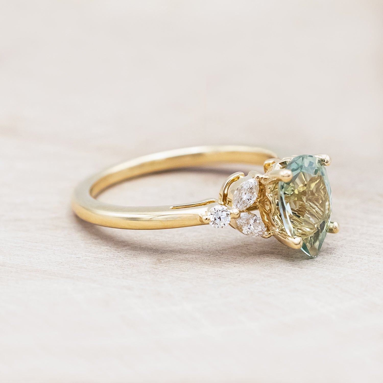 Side view of "Blossom" - pear cut lab-grown green sapphire women's engagement ring with diamond accents