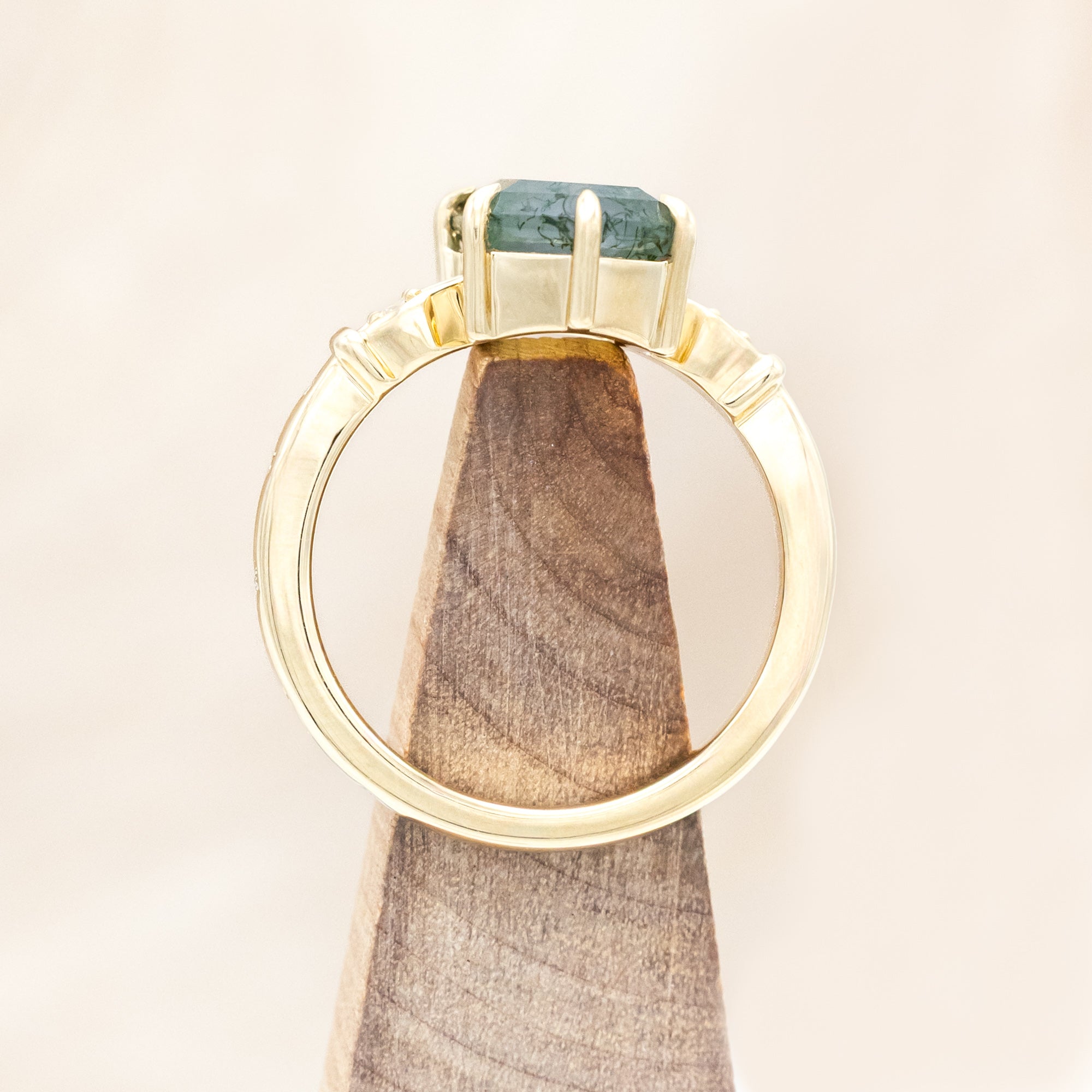 14K gold ring with moss agate and diamond accents on a light wooden surface