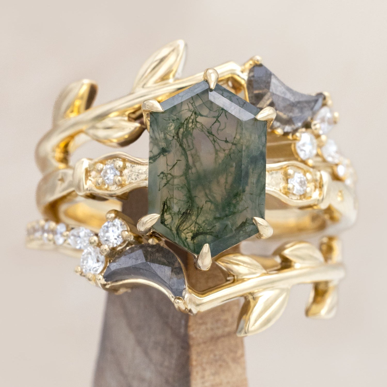 14K gold ring with a moss agate and two salt & pepper diamond tracers on a neutral background
