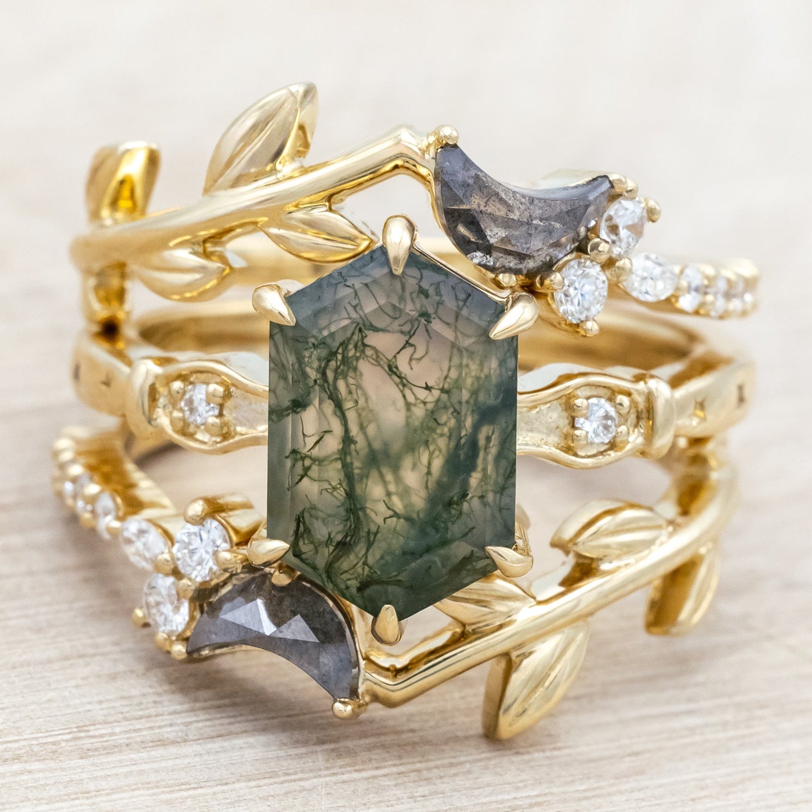 14K gold ring with a moss agate and two salt & pepper diamond tracers on a neutral background