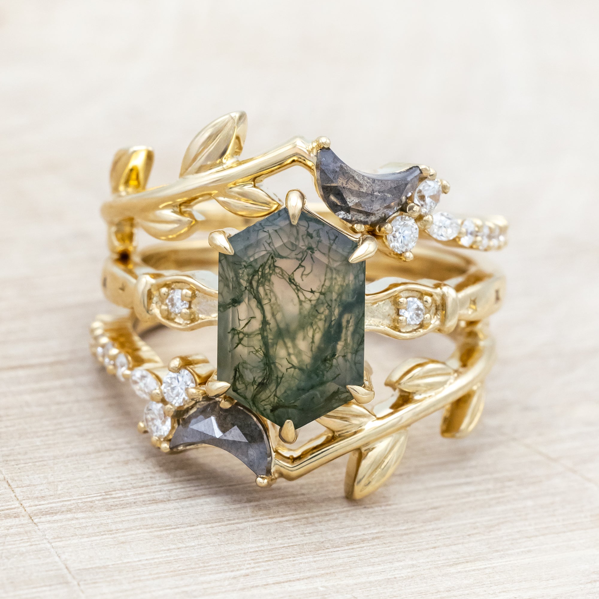14K gold ring with a moss agate and two salt & pepper diamond tracers on a neutral background