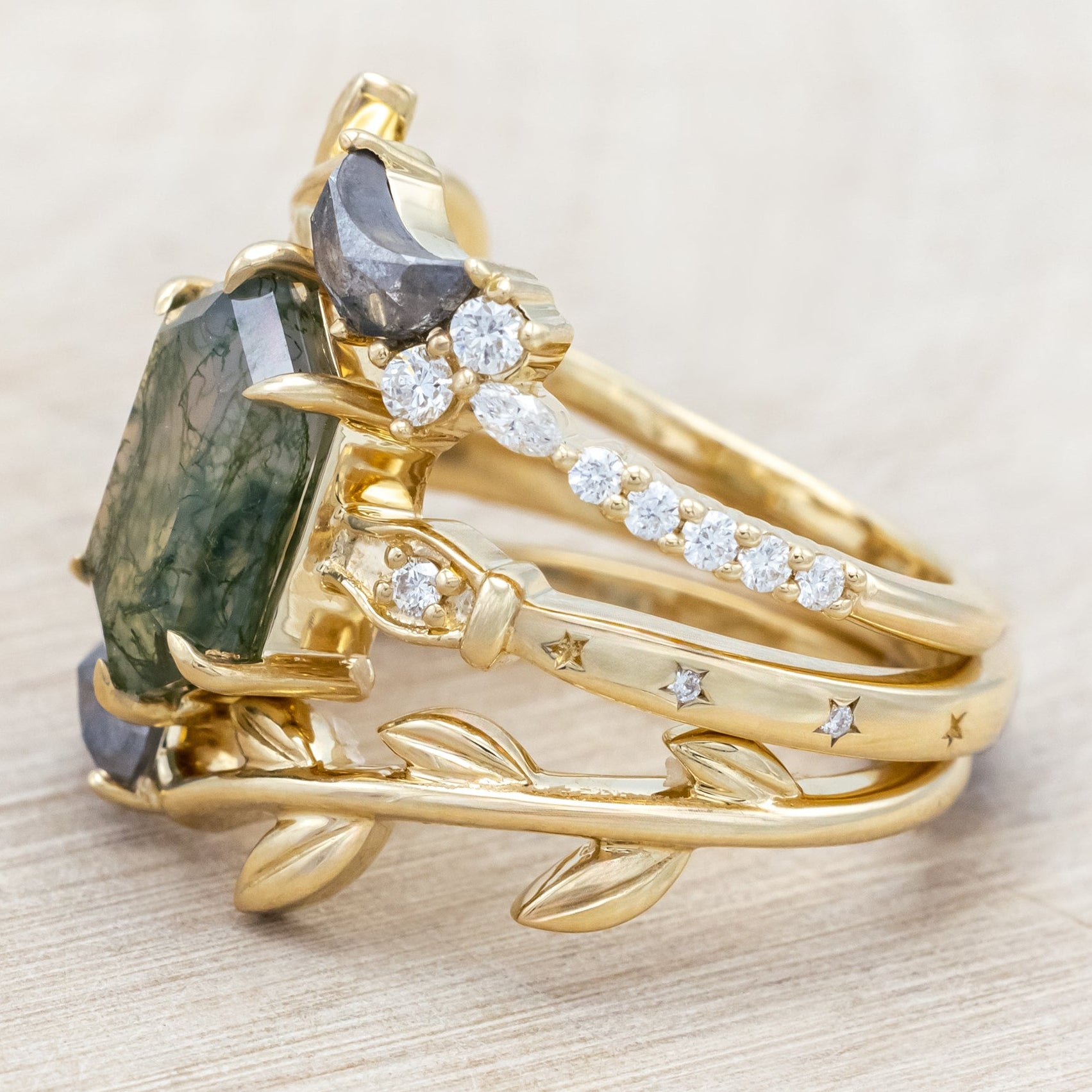 14K gold ring with a moss agate and two salt & pepper diamond tracers on a neutral background
