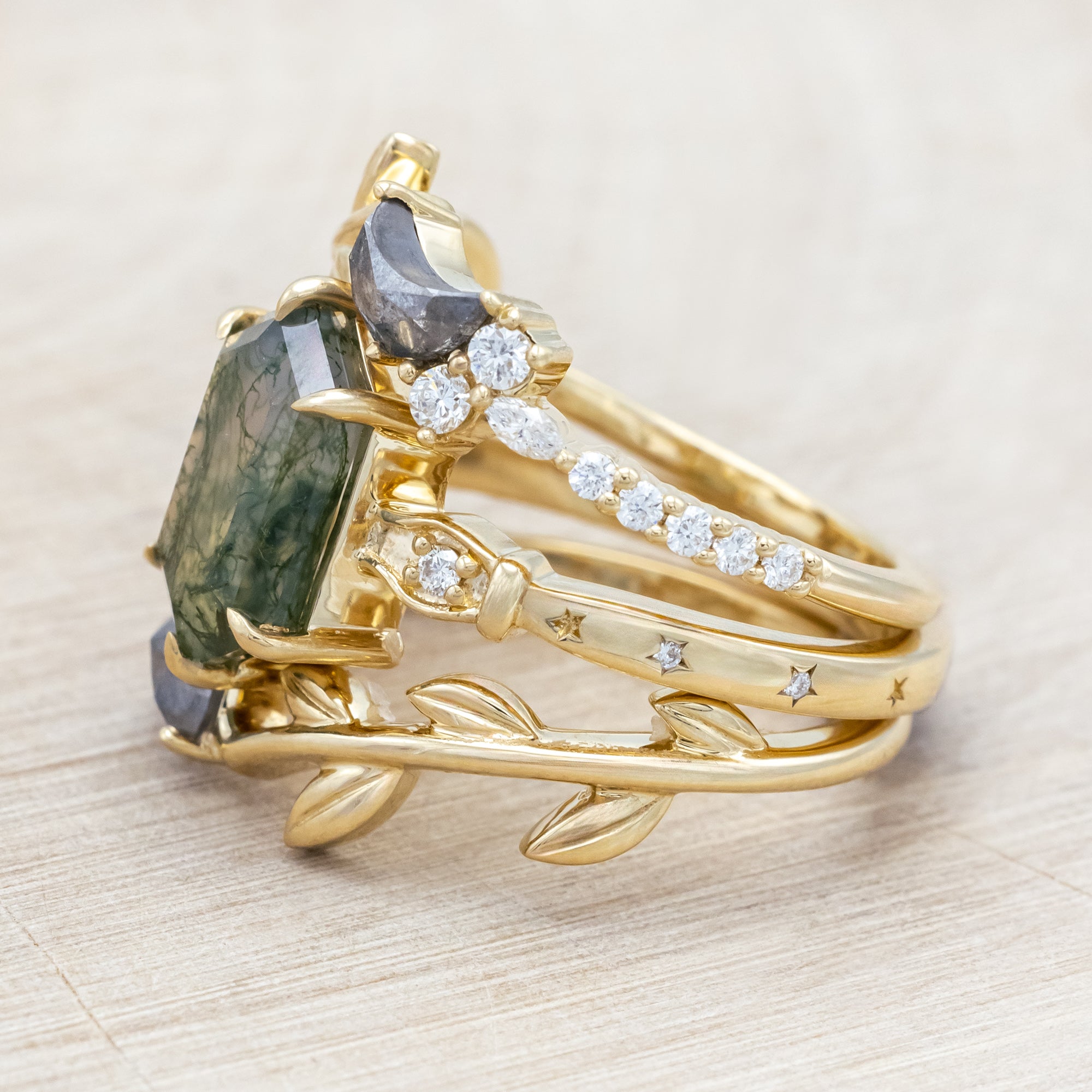 14K gold ring with a moss agate and two salt & pepper diamond tracers on a neutral background