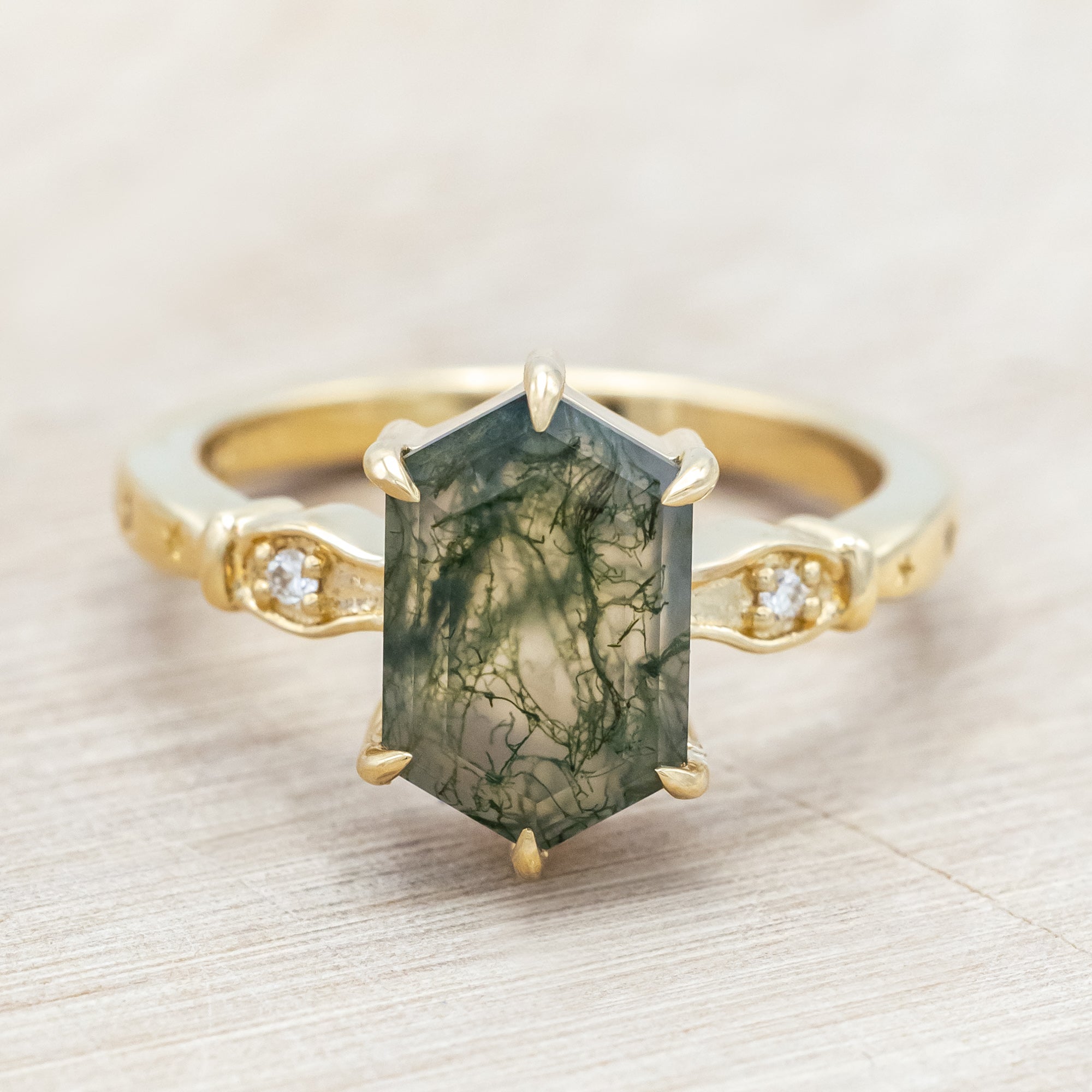14K gold ring with moss agate and diamond accents on a light wooden surface