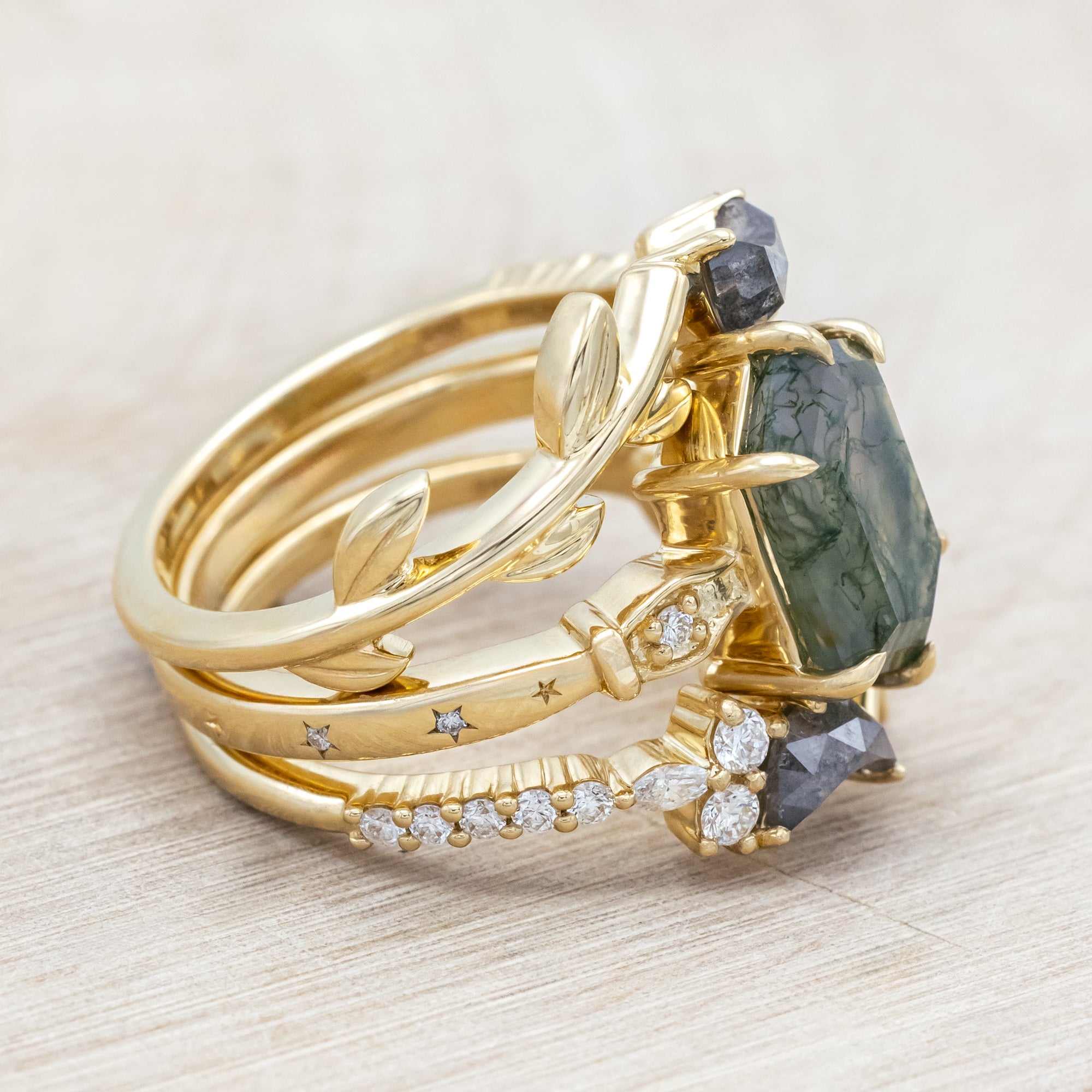 14K gold ring with a moss agate and two salt & pepper diamond tracers on a neutral background
