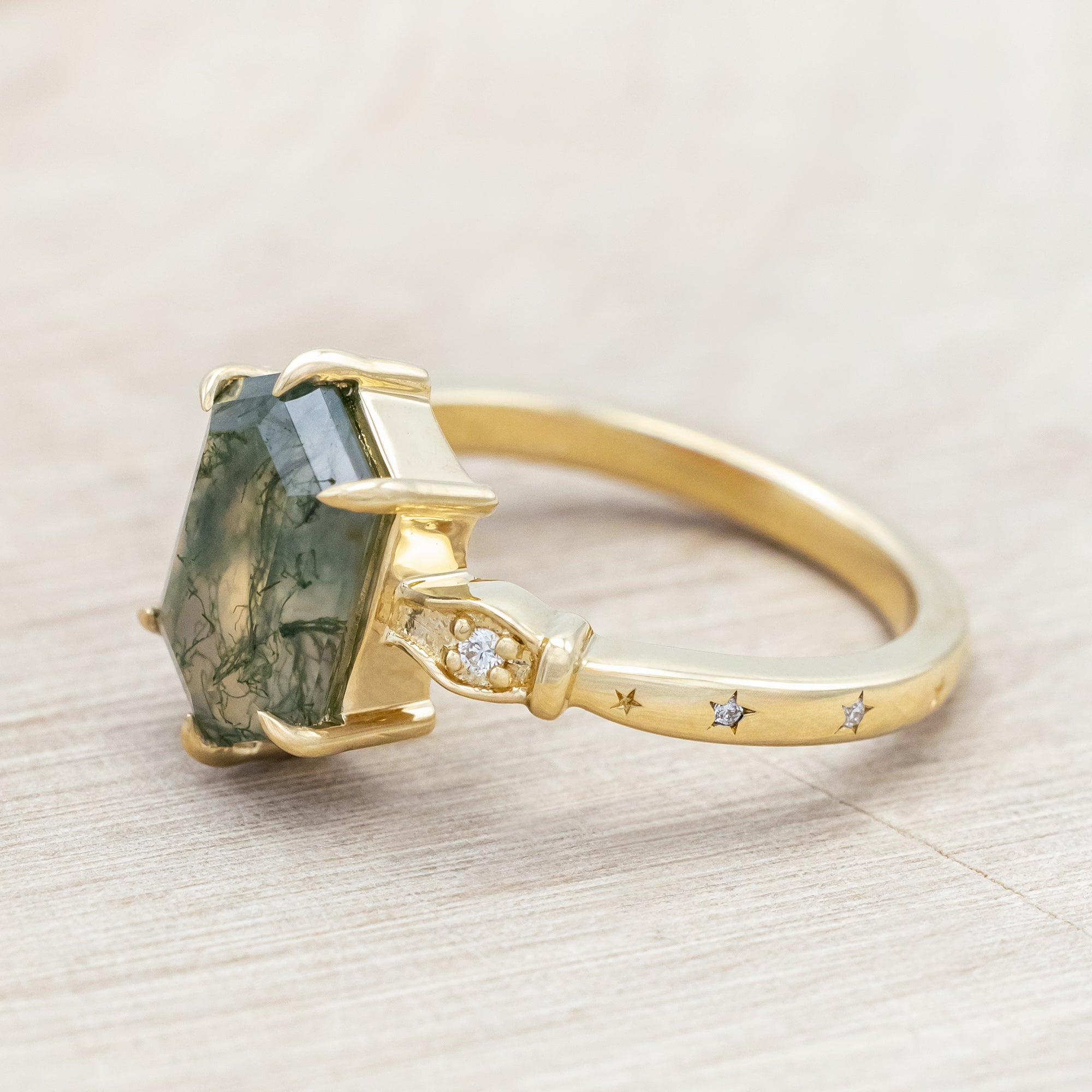 14K gold ring with moss agate and diamond accents on a light wooden surface