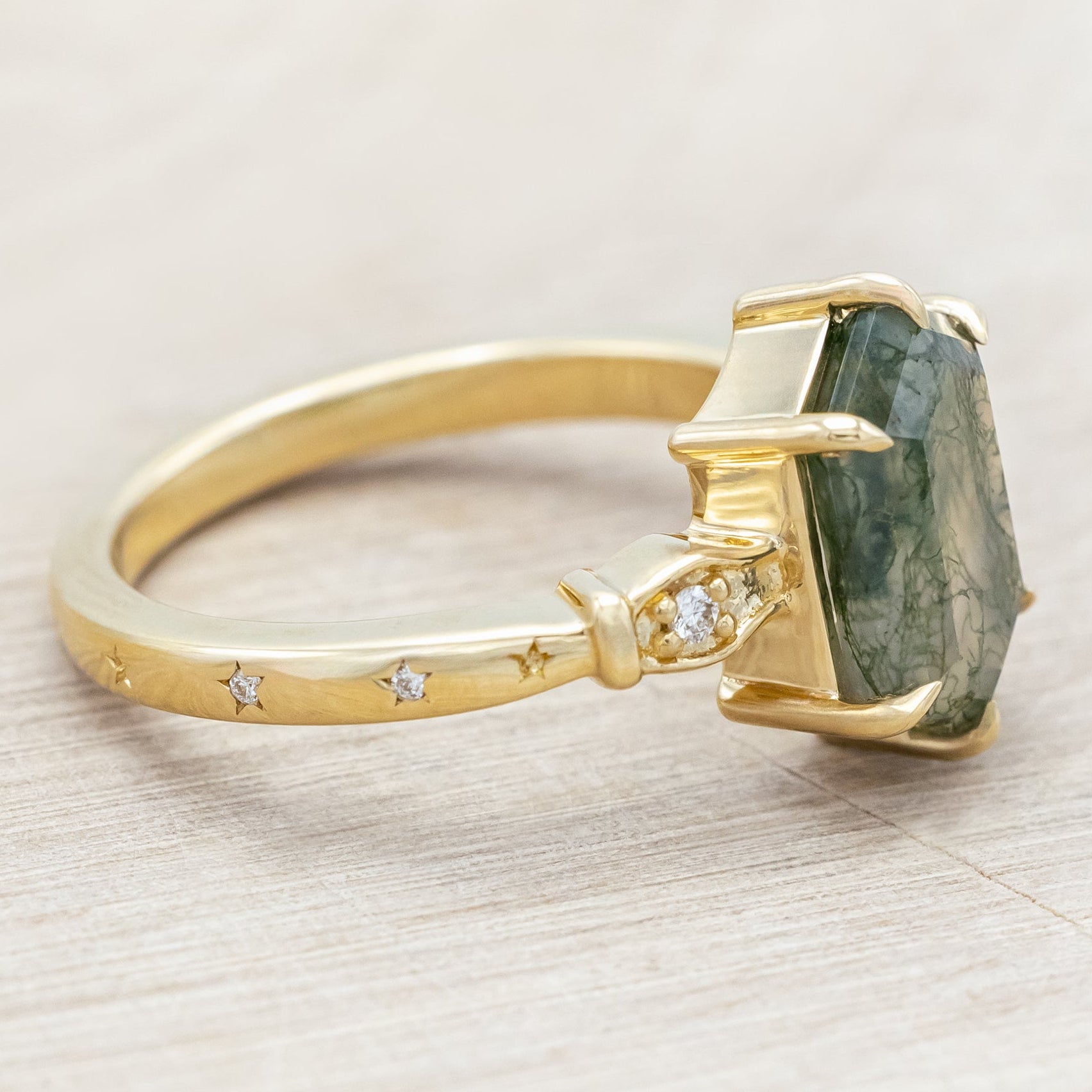 14K gold ring with moss agate and diamond accents on a light wooden surface