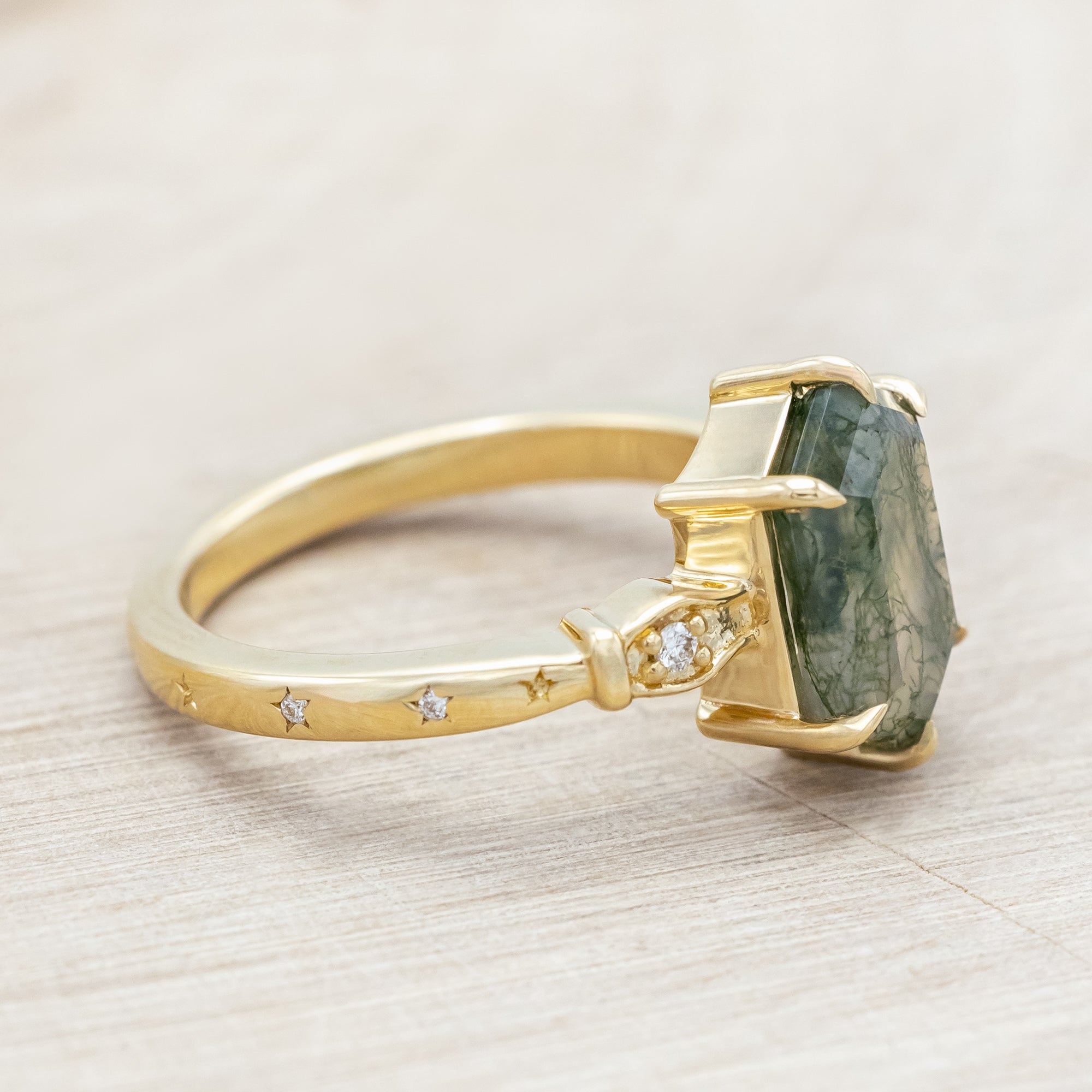 14K gold ring with moss agate and diamond accents on a light wooden surface