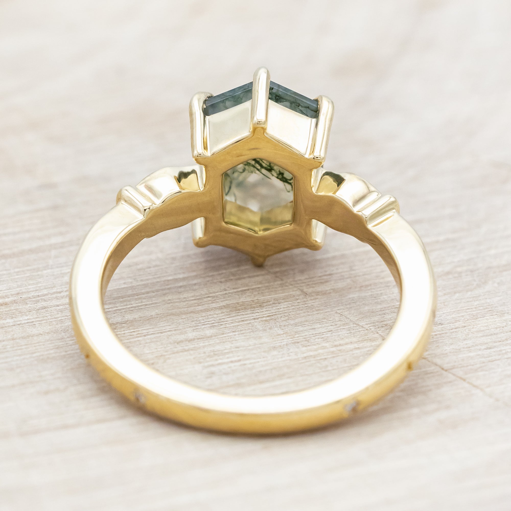 14K gold ring with moss agate and diamond accents on a light wooden surface