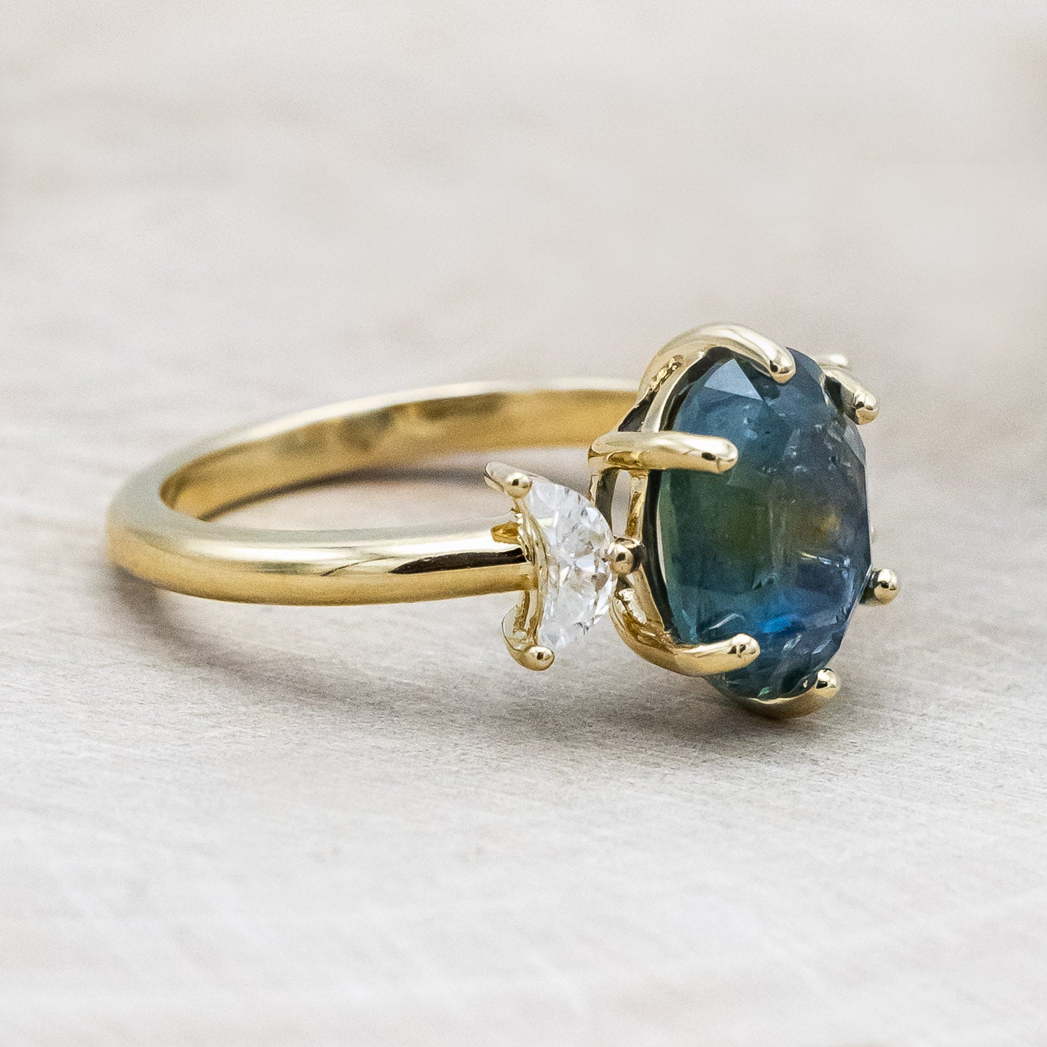 "Rhiannon" engagement ring with a portrait cut Montana sapphire and two crescent moon moissanite accents