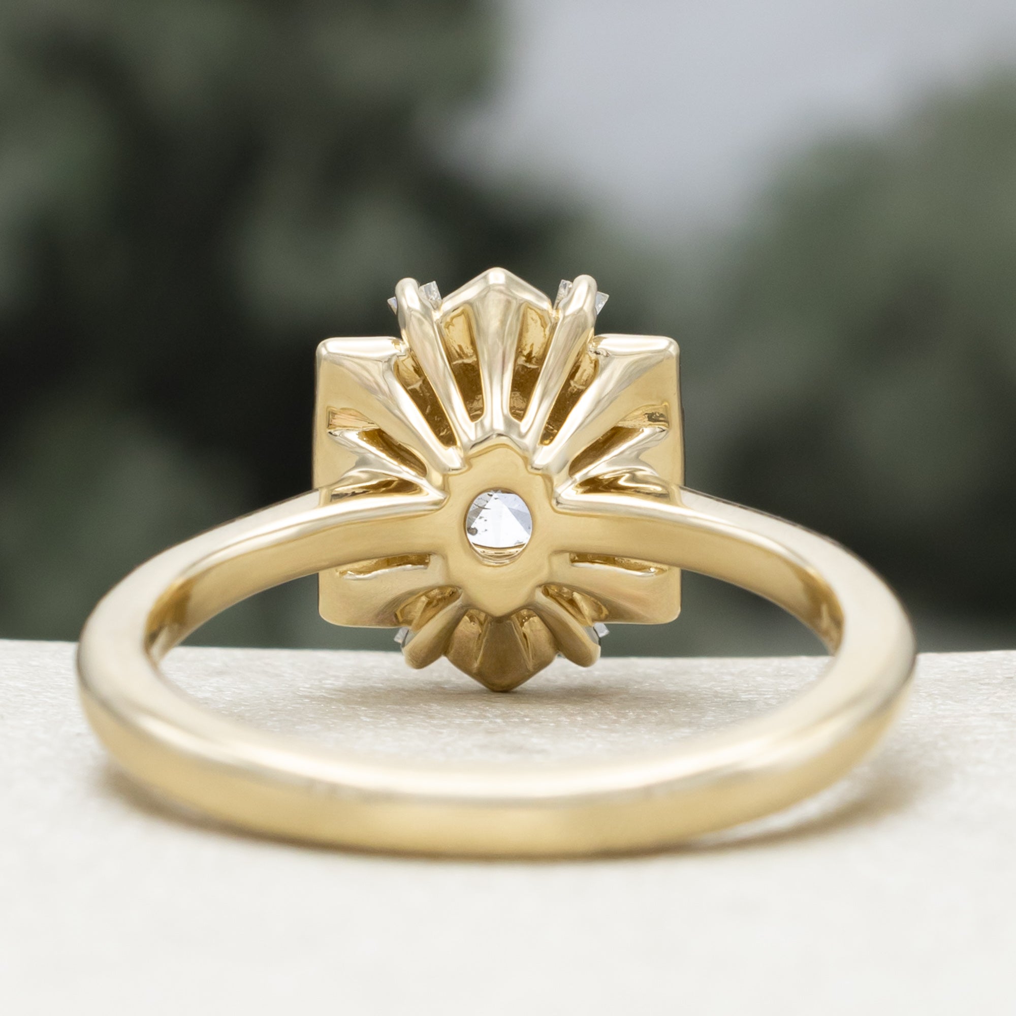 Gold ring with a champagne diamond center stone against a blurred green background