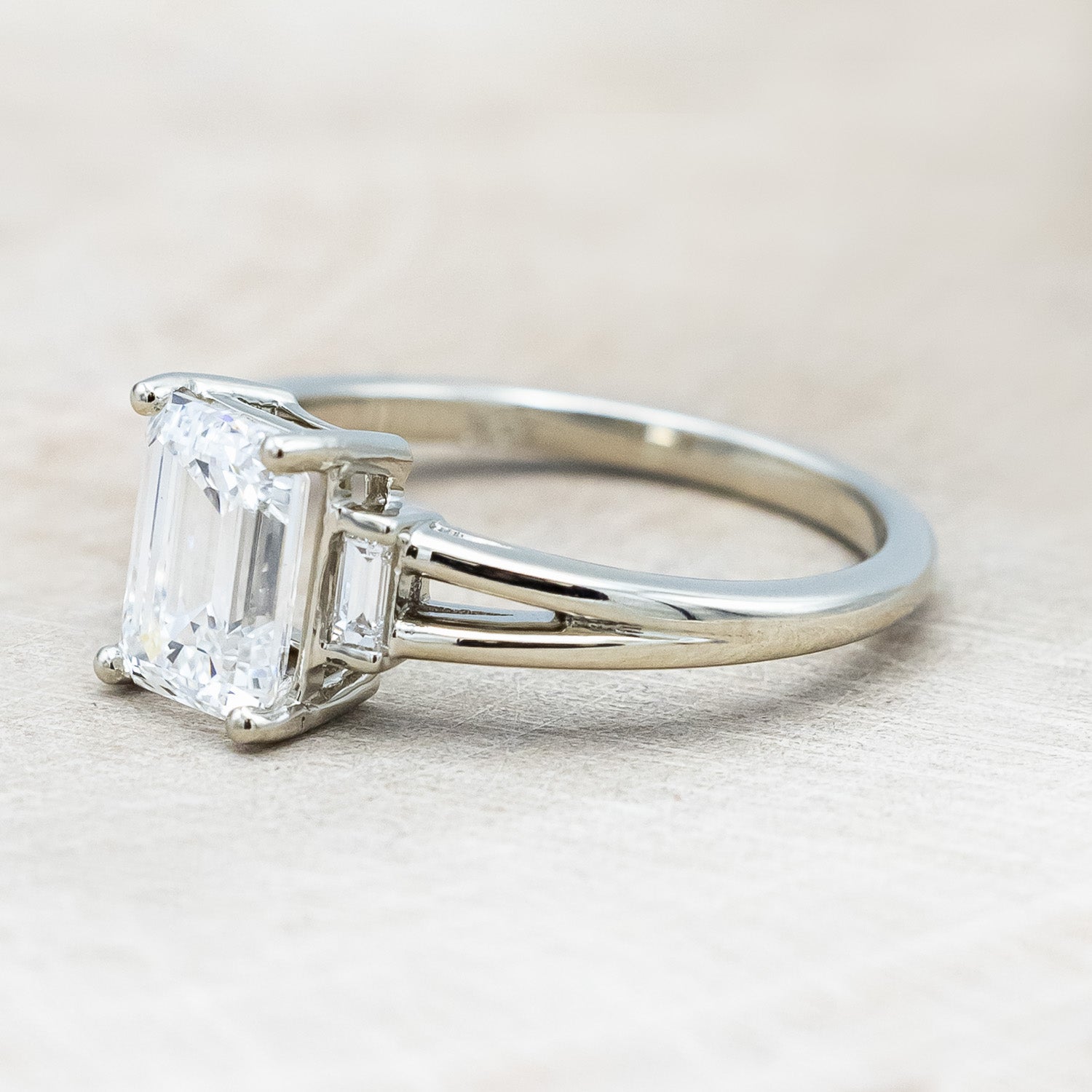 Side view of "Corella" - emerald cut lab-grown diamond women's engagement ring with diamond accents