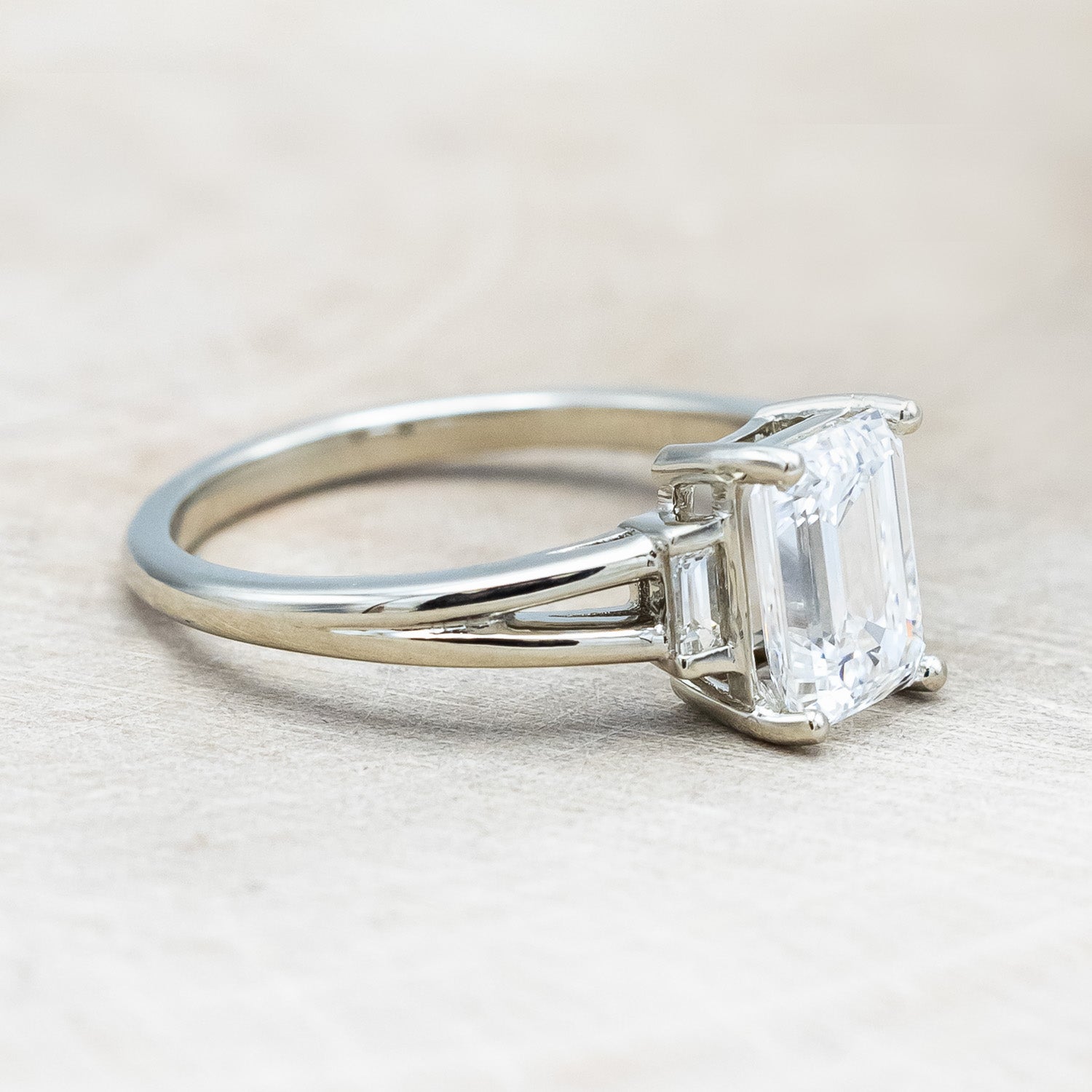 Side view of "Corella" - emerald cut lab-grown diamond women's engagement ring with diamond accents