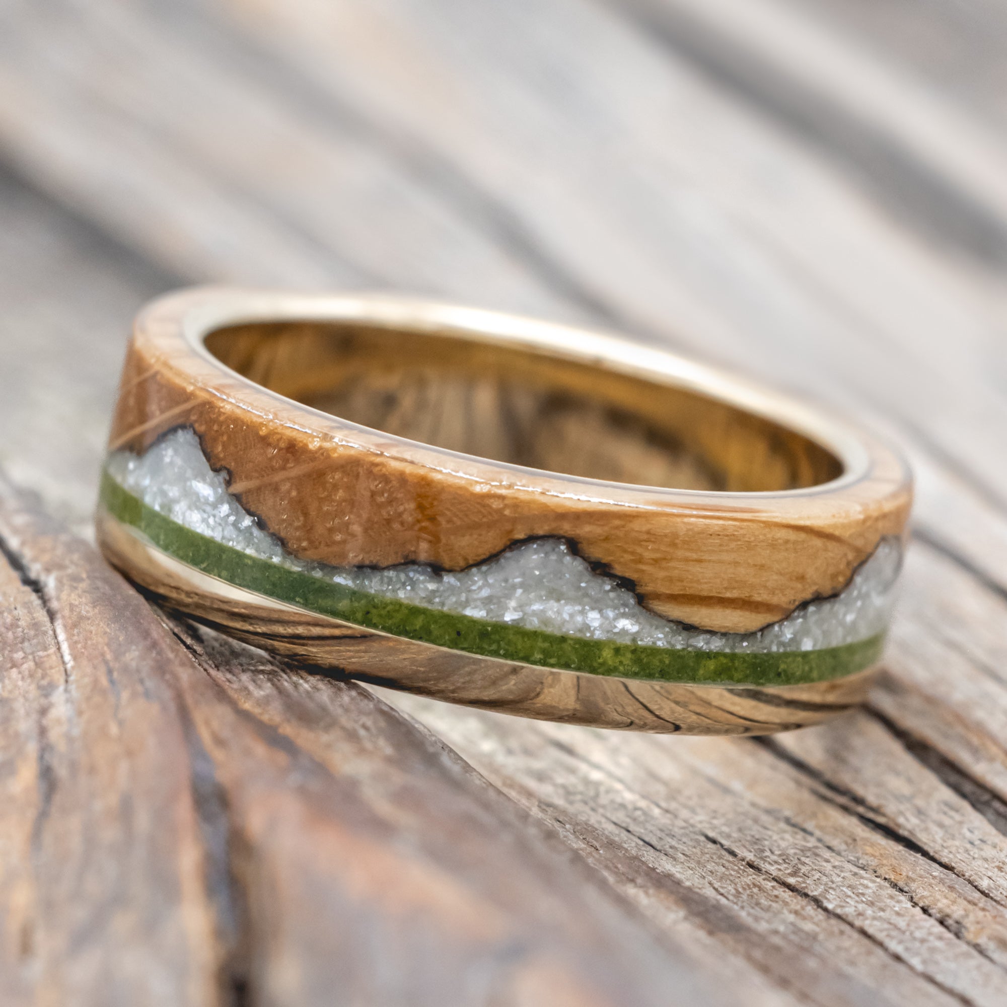 whiskey barrel oak ring with moss and diamond dust inlay on a wooden surface