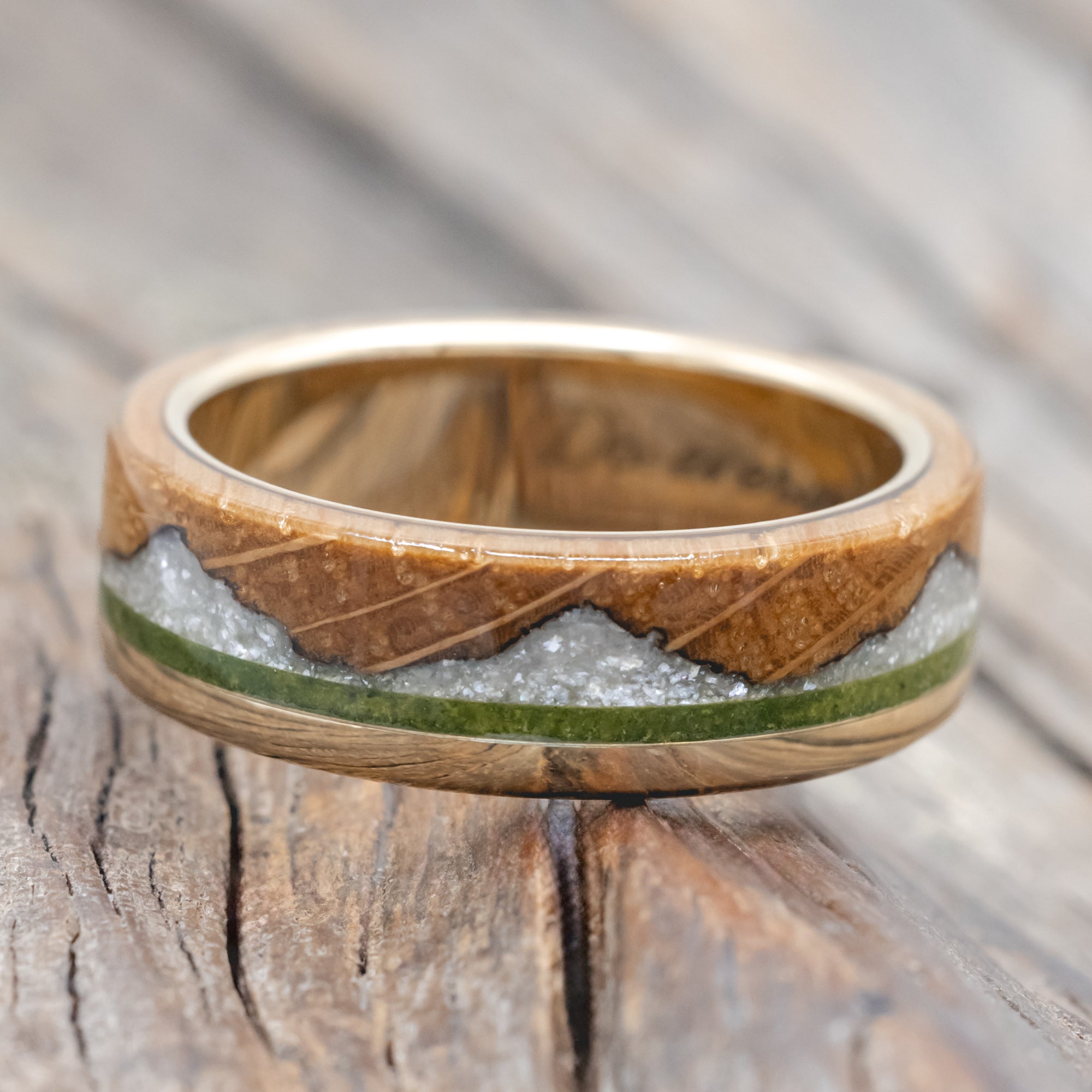 whiskey barrel oak ring with moss and diamond dust inlay on a wooden surface