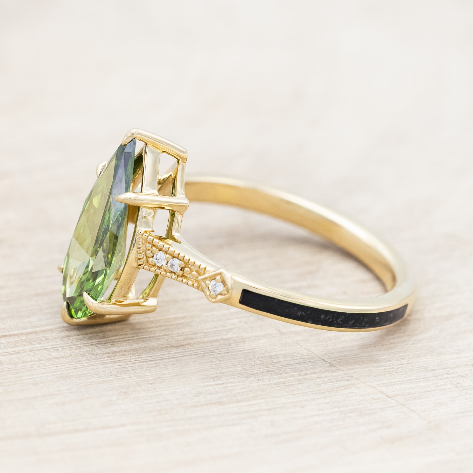 14K yellow gold ring with a green diamond on a neutral background