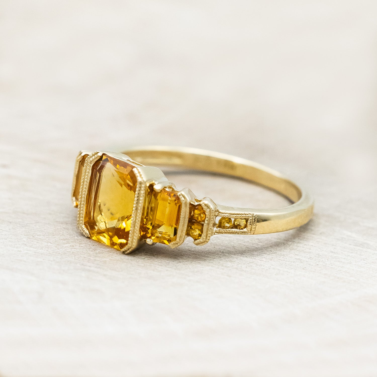 Side view of "Hazel" - accented-style citrine women's engagement ring with citrine accents on a 14K gold miligrain band