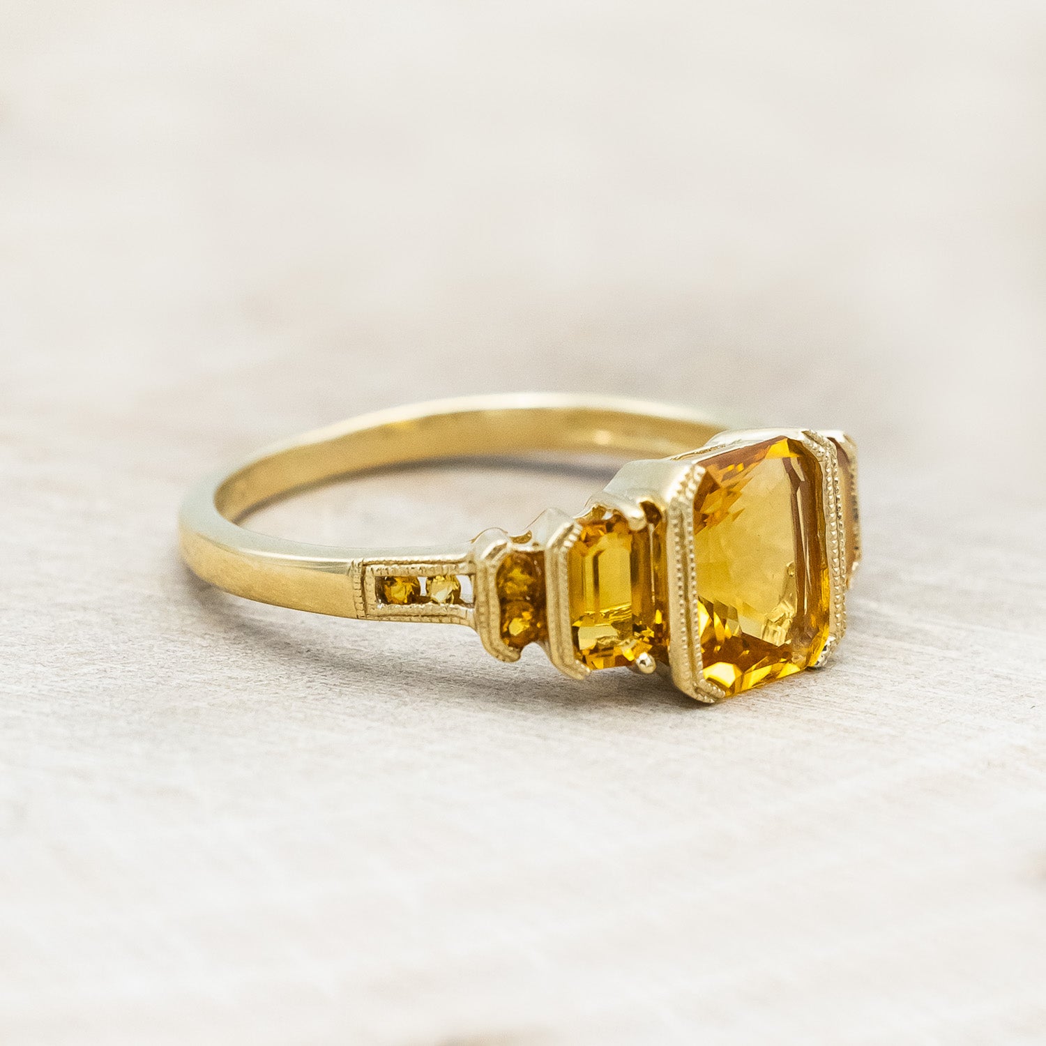 Side view of "Hazel" - accented-style citrine women's engagement ring with citrine accents on a 14K gold miligrain band
