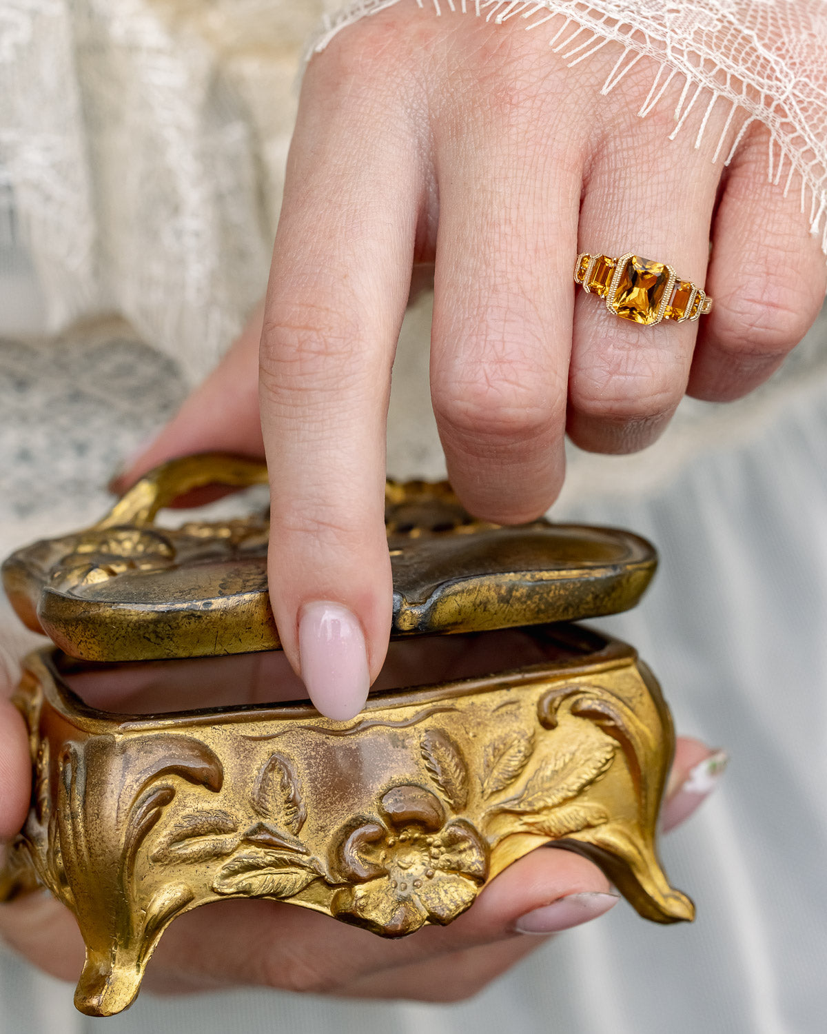 On hand photo of "Hazel" - accented-style citrine women's engagement ring with citrine accents on a 14K gold miligrain band