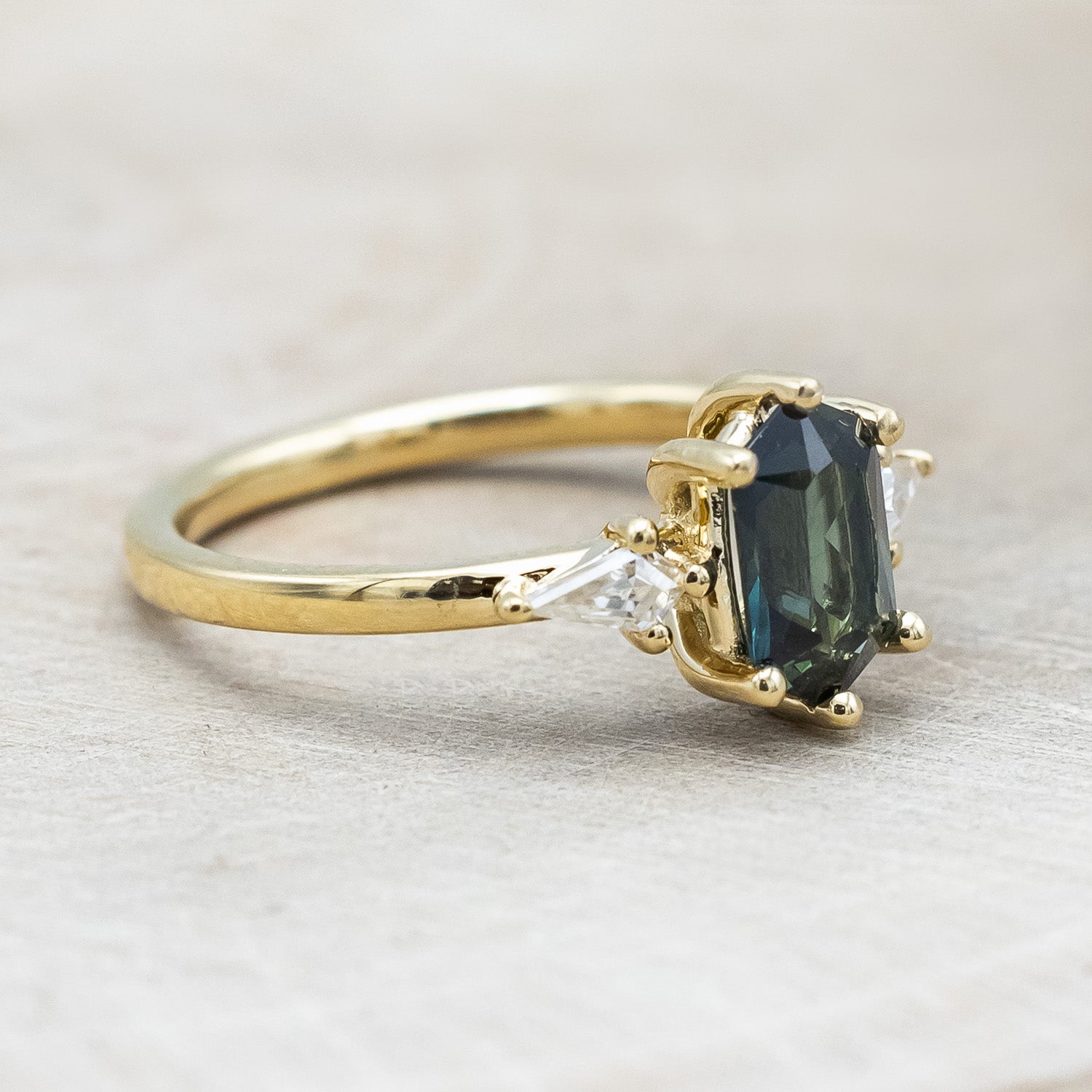 Side view of "Isla" - elongated hexagon cut Australian sapphire with moissanite accents in 14K yellow gold