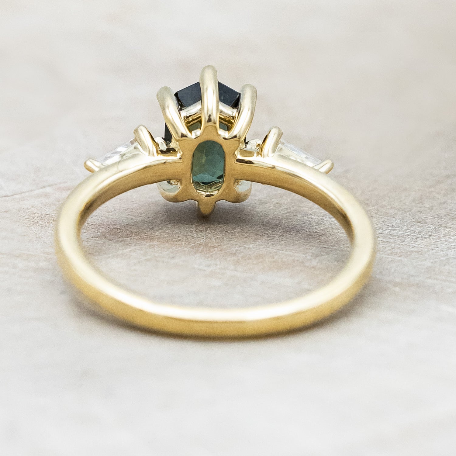 Back view of "Isla" - elongated hexagon cut Australian sapphire with moissanite accents in 14K yellow gold