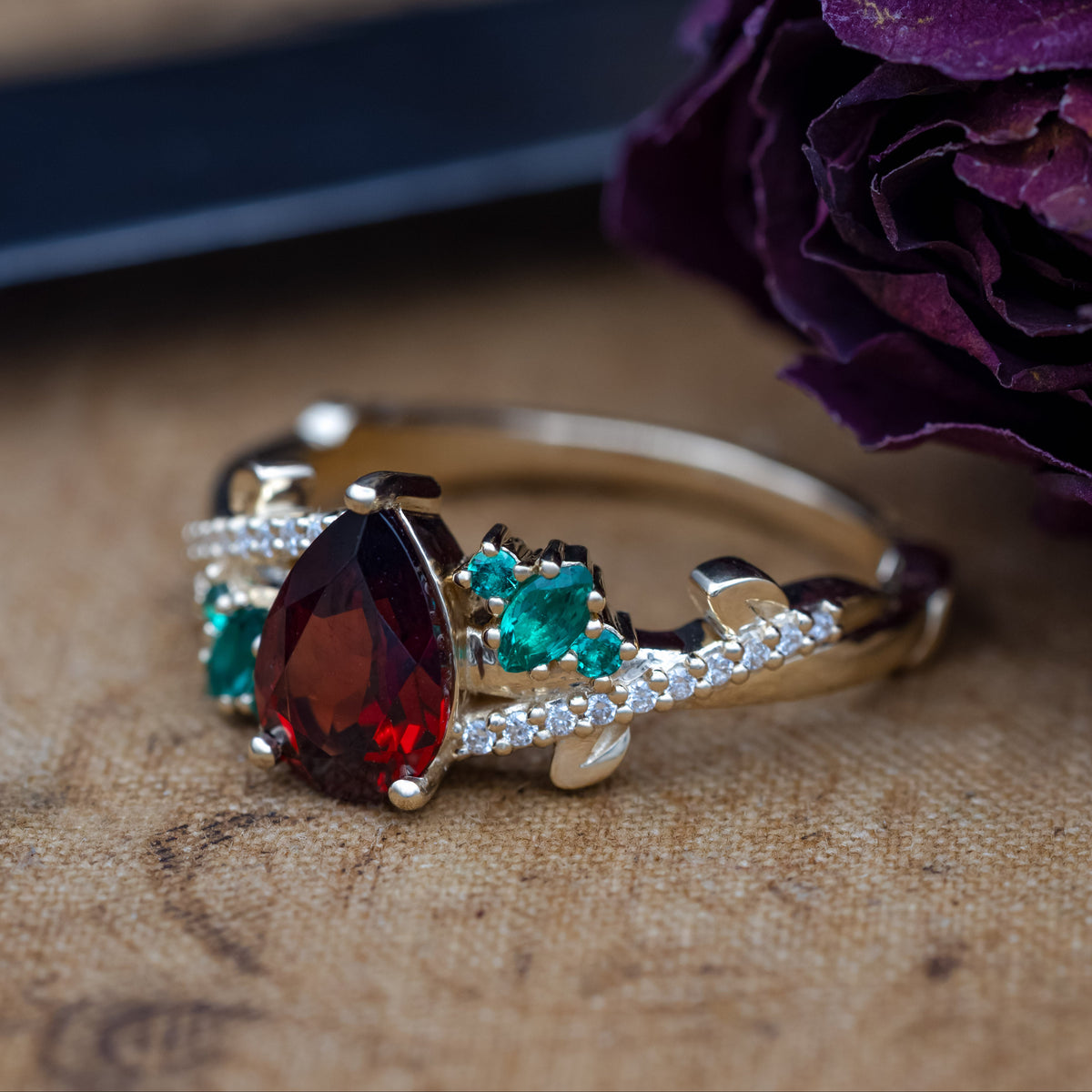 "Kamila" - Pear Cut Mozambique Garnet Engagement Ring With Lab-Grown Emerald & Diamond Accents-Staghead Designs