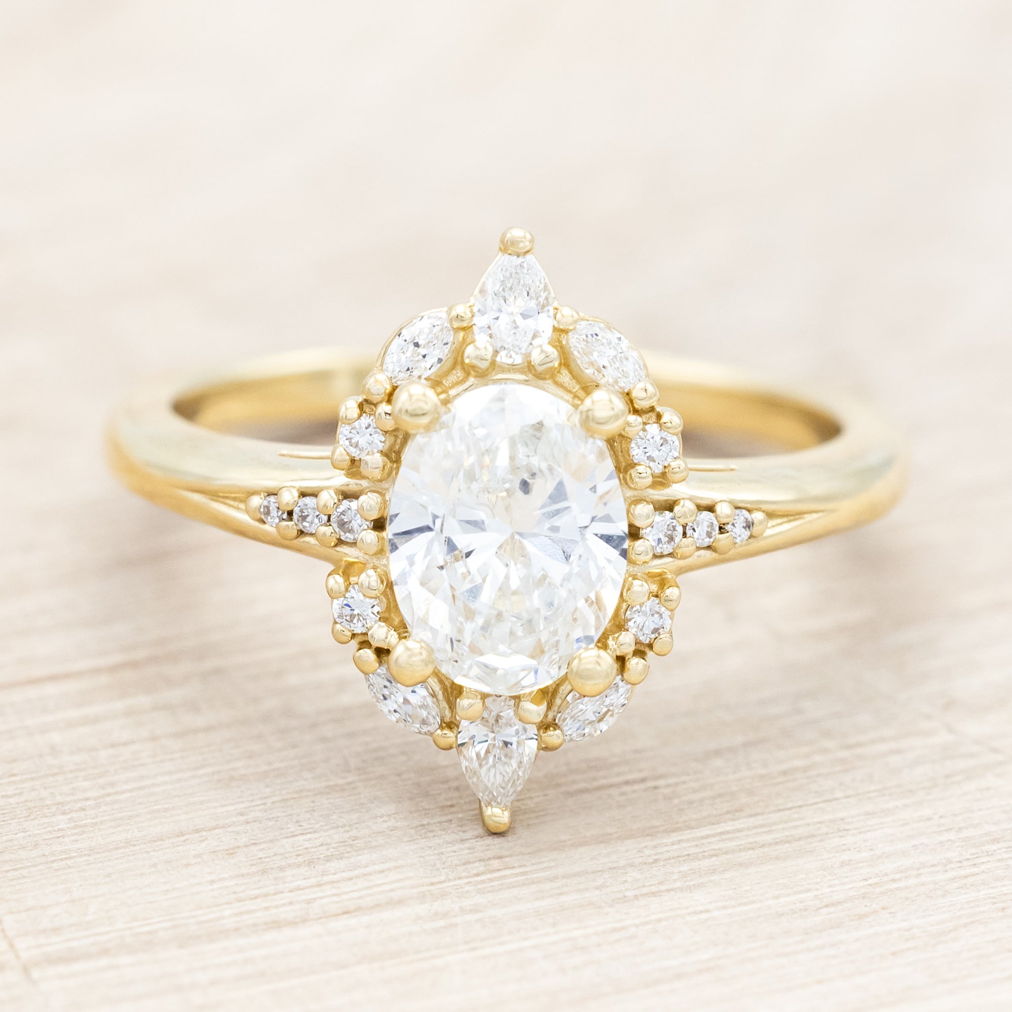 14K gold ring with an oval lab diamond on a beige background