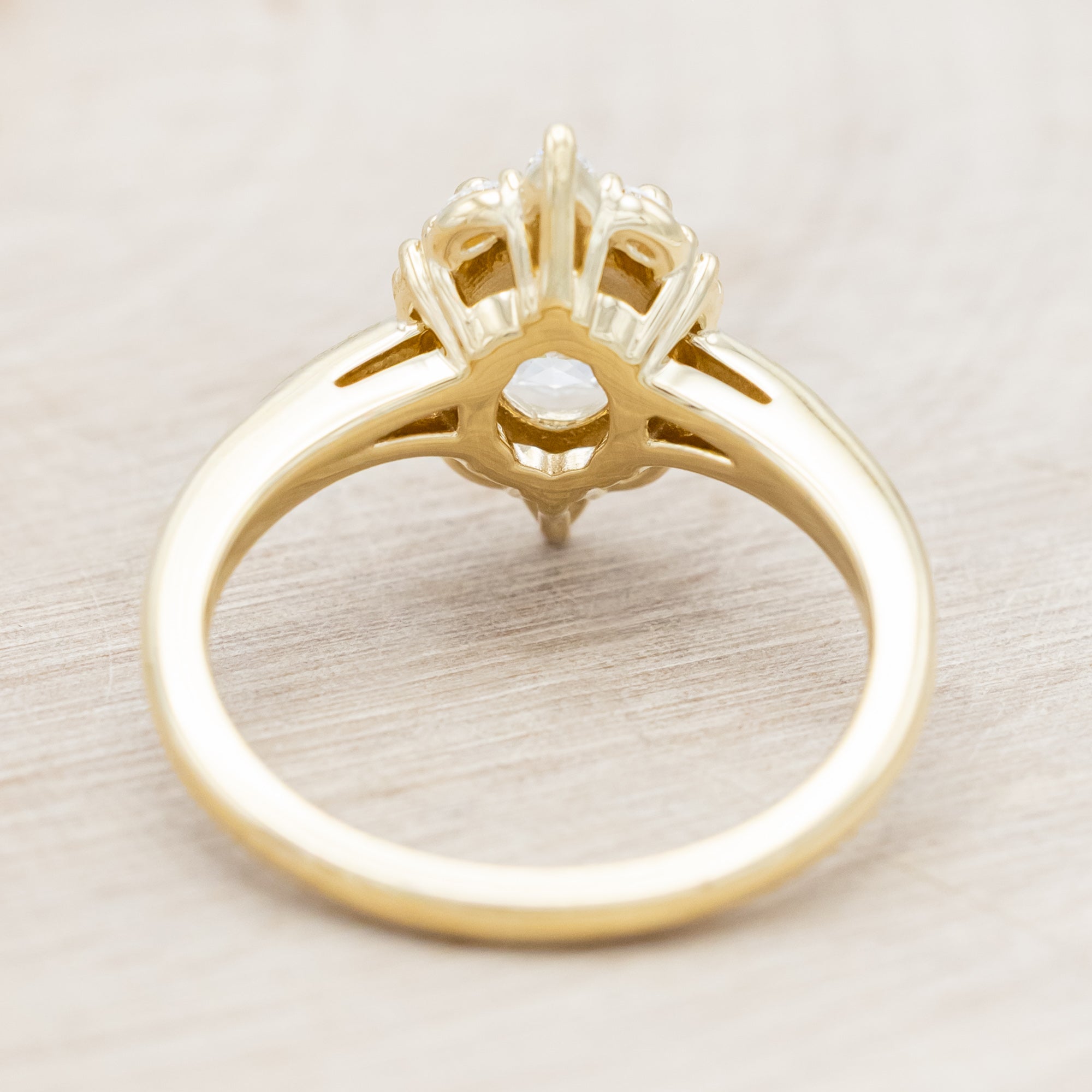 14K gold ring with an oval lab diamond on a beige background