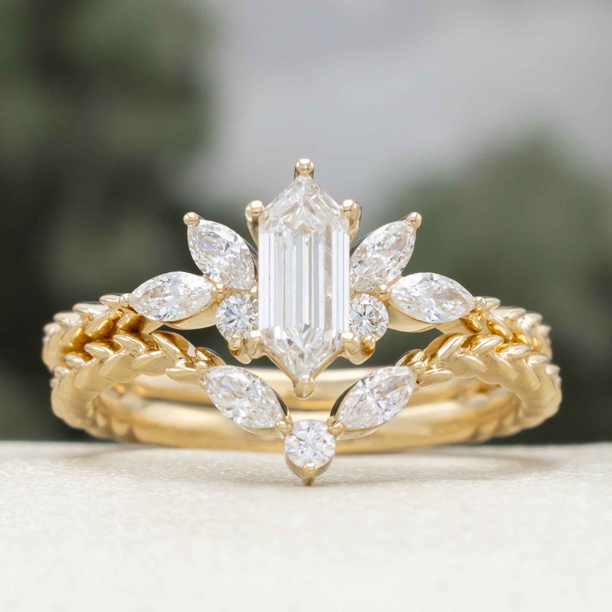 Gold ring with diamond centerstone and  accents on a neutral background